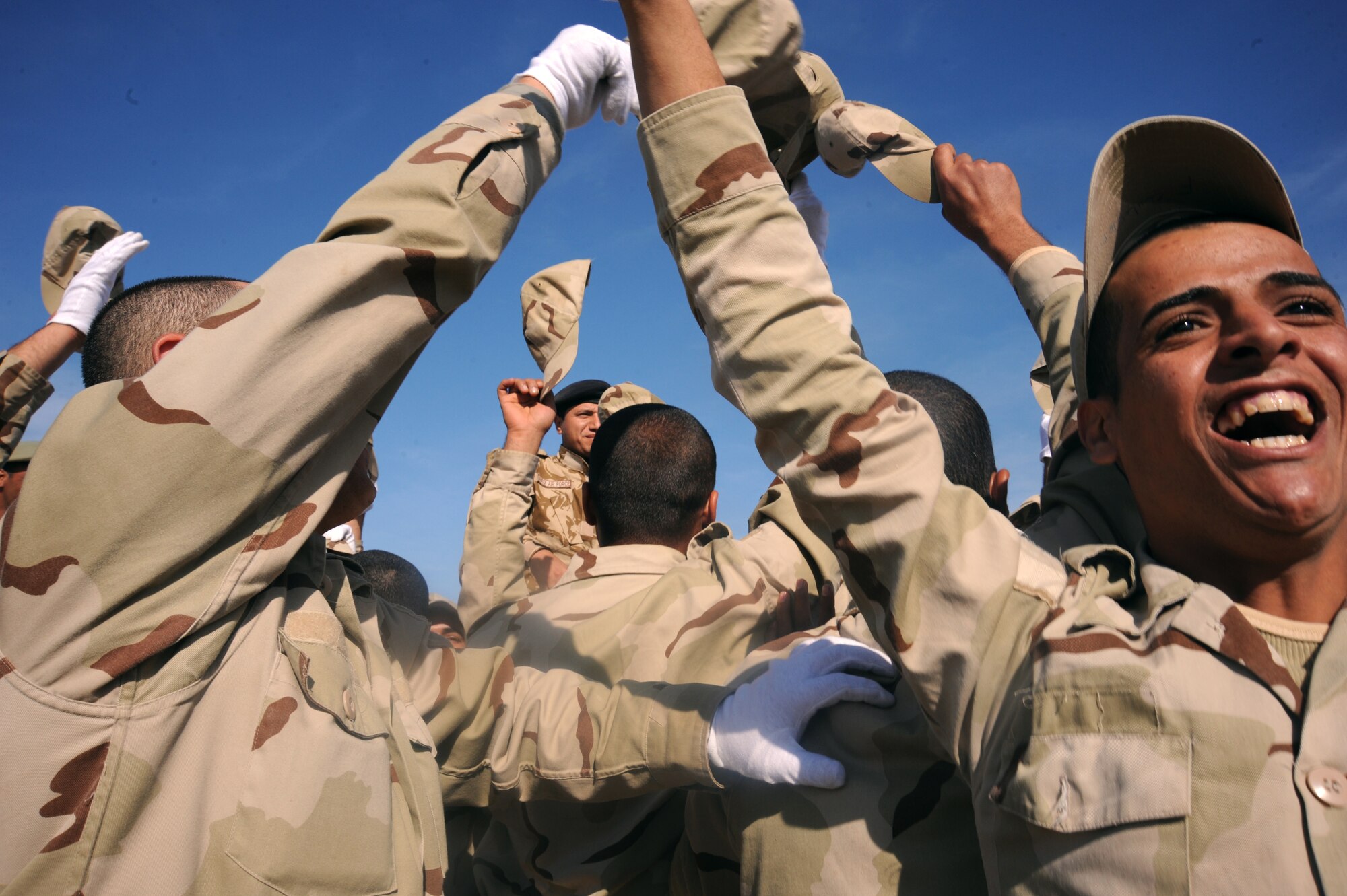 CAMP TAJI, Iraq -- Iraqi air force recruits celebrate after their graduation from the basic military training Top Off course at the Iraqi Air Force Training School Dec. 28, 2009. The Top Off course teaches recruits about rank structure, leadership and what kind of benefits they will receive. (U.S. Air Force photo/Master Sgt. Trish Bunting)