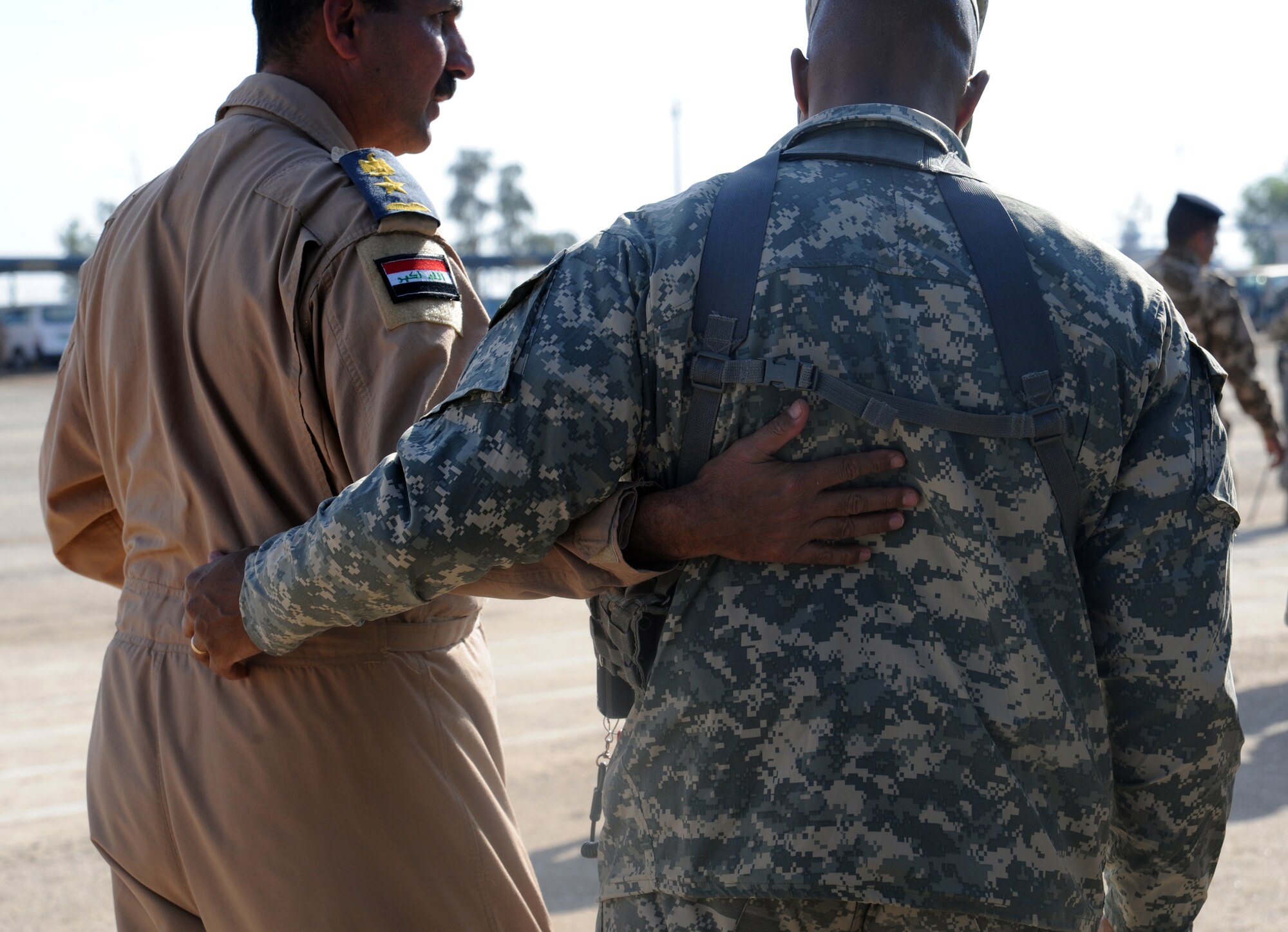 CAMP TAJI, Iraq -- A U.S. Army servicemember embraces an Iraqi servicemember after a basic military training Top Off course graduation ceremony at the Iraqi Air Force Training School Dec. 28, 2009.  The U.S. Air Force played an advisory role in this completely Iraqi-led air force training course. (U.S. Air Force photo/Master Sgt. Trish Bunting)