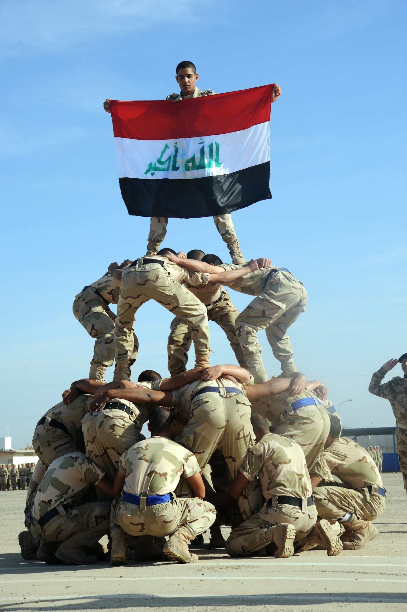 CAMP TAJI, Iraq -- Iraqi air force recruits build a human pyramid during their graduation ceremony from the basic military training Top Off course at the Iraqi Air Force Training School Dec. 28, 2009. The Top Off course teaches recruits about rank structure, leadership and what kind of benefits they will receive. (U.S. Air Force photo/Master Sgt. Trish Bunting)