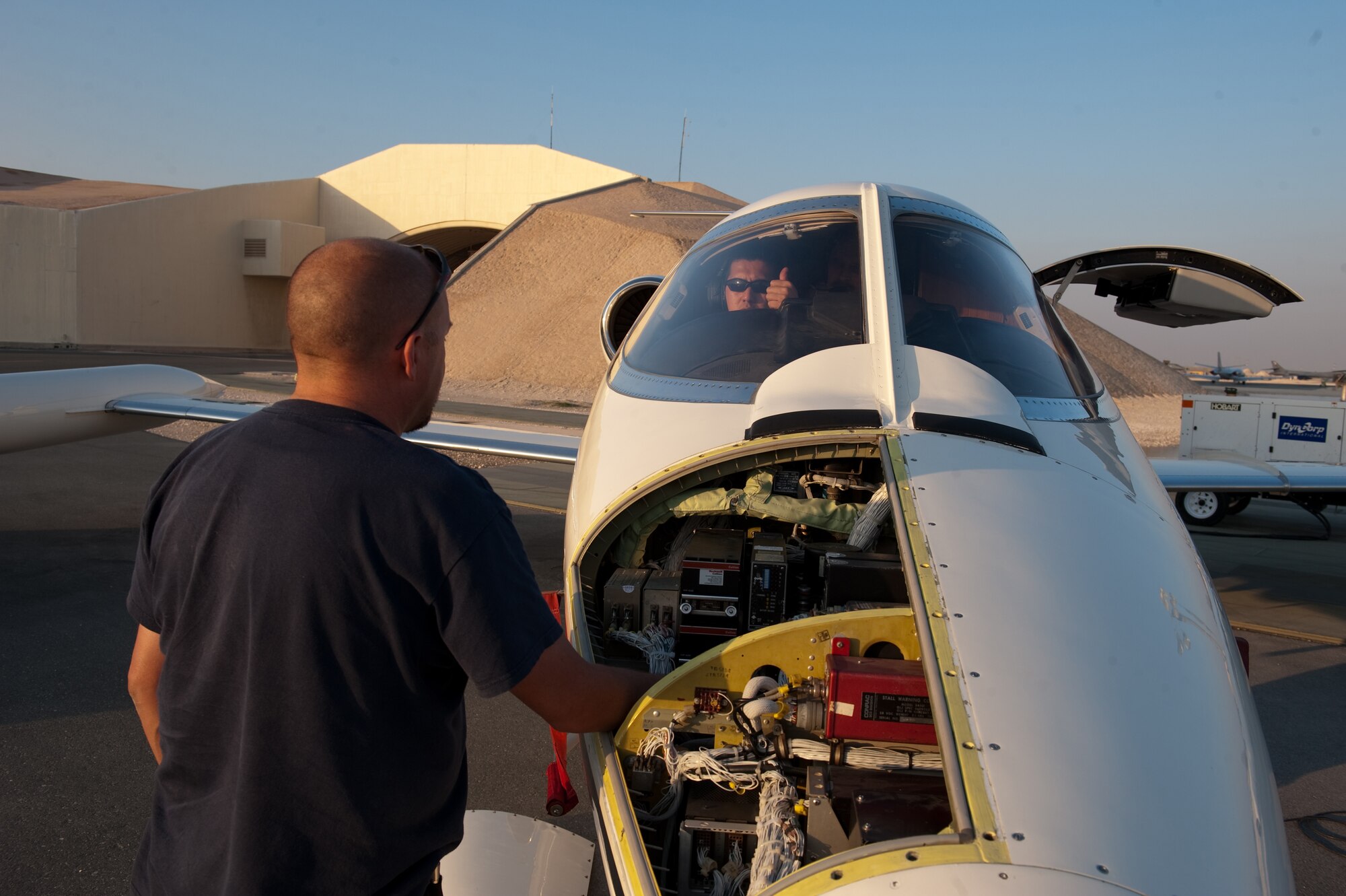 Left, Mr. Robert Jalbert, Dyncorp airframe and power plant mechanic, troubleshoots the radio system on a C-21 with Mr. Dan Veloso, Dec. 27, 2009, in Southwest Asia. Dyncorp contractors provide total aircraft system maintenance services, logistical support, and management processes to maintain the C-21 fleet in operation throughout the U.S. Central Command area of responsibility. (U.S. Air Force photo/Staff Sgt. Robert Barney/RELEASED)