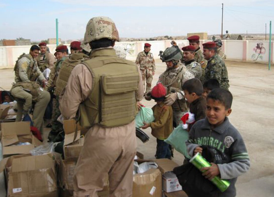 Iraqi soldiers with the 7th Iraqi Army Division hand out gifts and school supplies to Iraqi children near Baghdadi, Iraq, Dec. 31, 2009. Marines from 3rd Battalion, 24th Marine Regiment, gave their excess supplies and care package items to the Iraqi soldiers for distribution to the community.