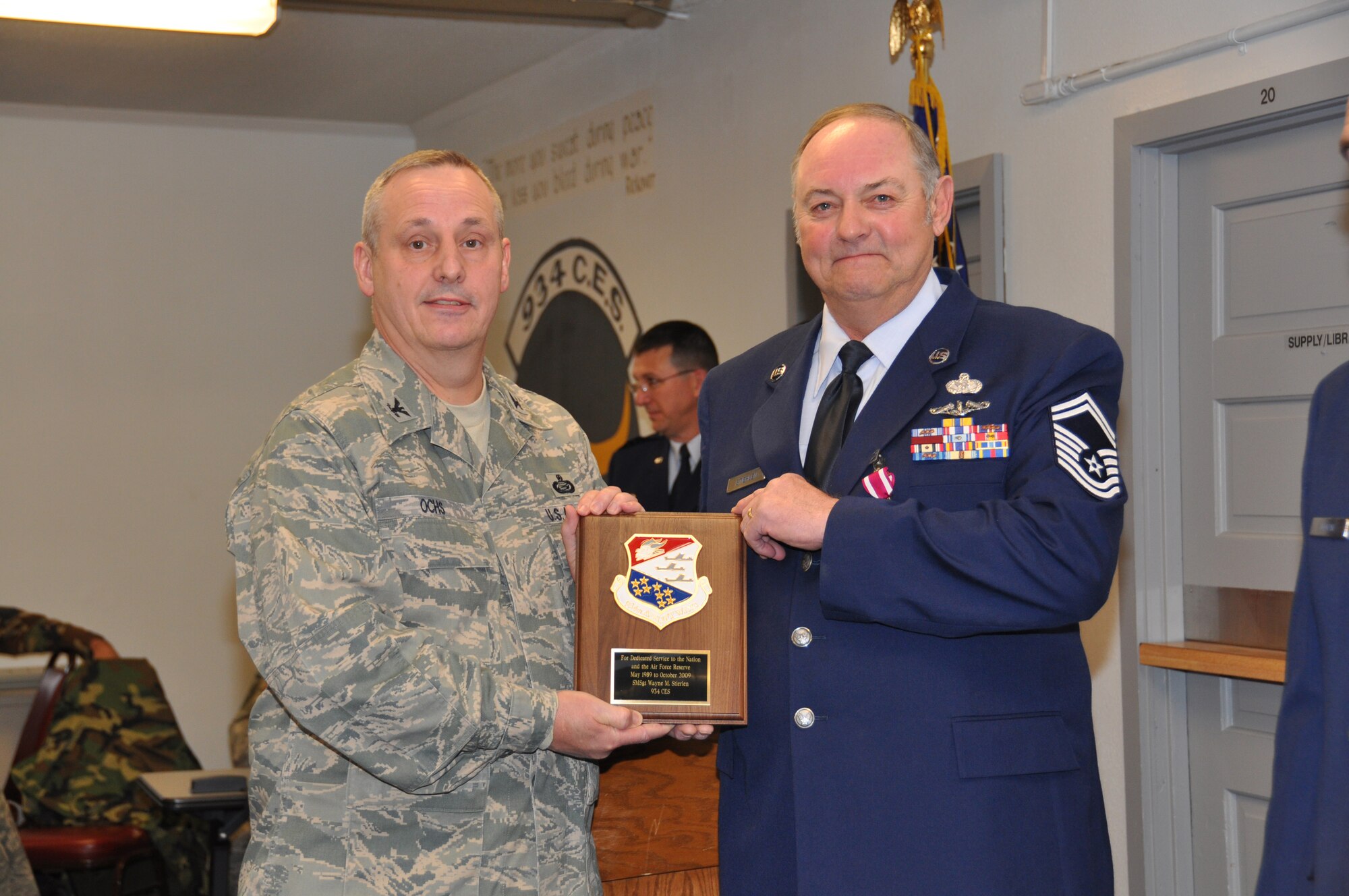 Senior Master Sgt. Wayne Stierlen, 934th Civil Engineer Squadron receives his retirement plaque from Col. Mike Ochs, 934th Mission Support Group commander, Nov. 7. Sergeant Stierlen retired with more than 26 years service.