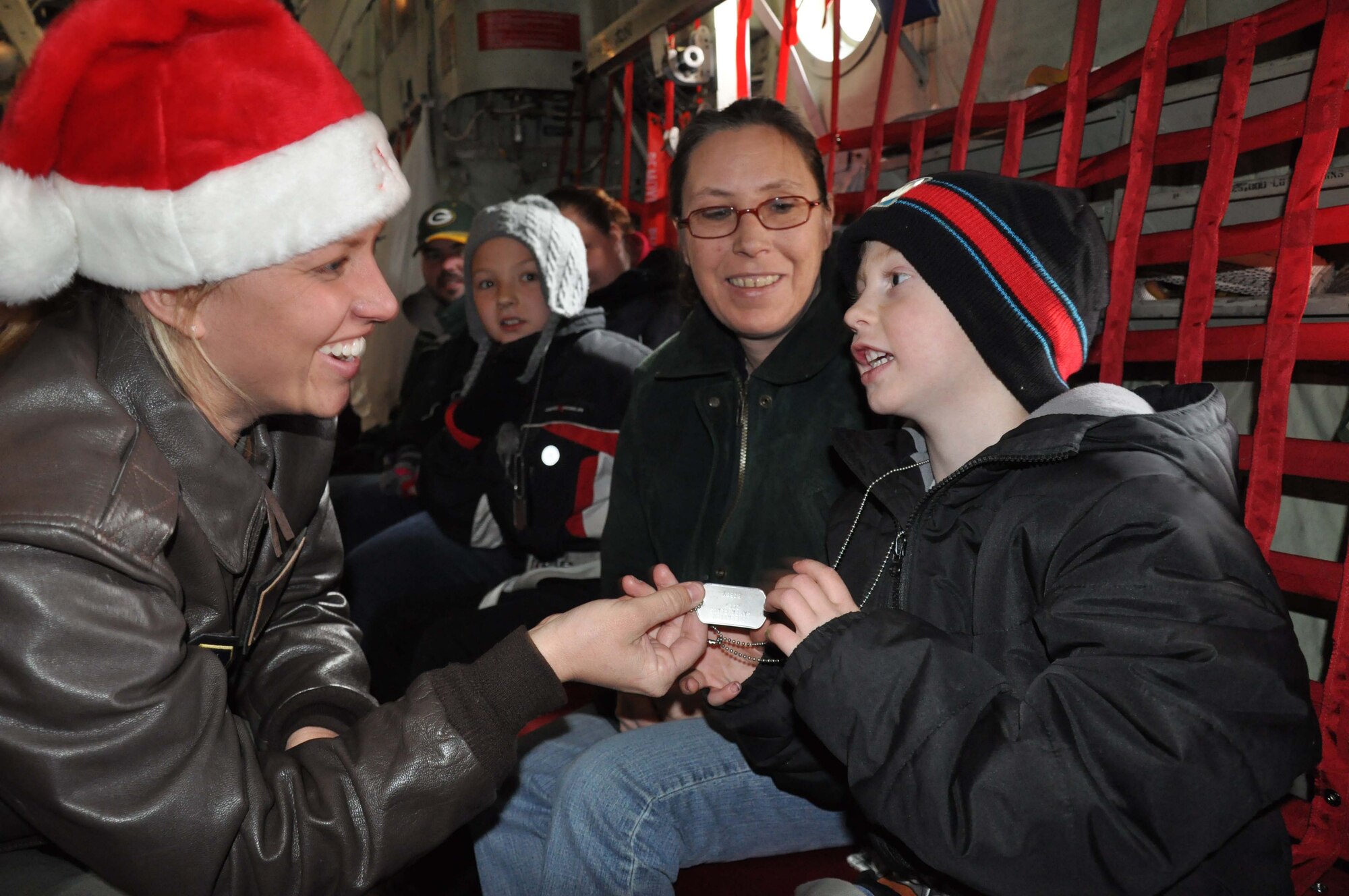 2nd Lt. Amanda Piersak, 934th Aeromedical Evacuation Squadron, gives a dog tag to a child on the way to the ?North Pole? during Operation Santa. (Air Force Photo/Tech. Sgt. Bob Sommer)