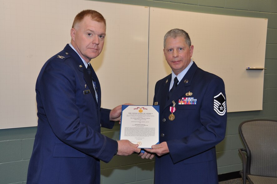 Master Sgt. Donald Johnson, 934th Operations Group, receives the Meritorious Service Medal citation from Col. Ron Wilt, 934th Operations Group commander, at his retirement ceremony Nov. 7. Sergeant Johnson retired with more than 26 years service.