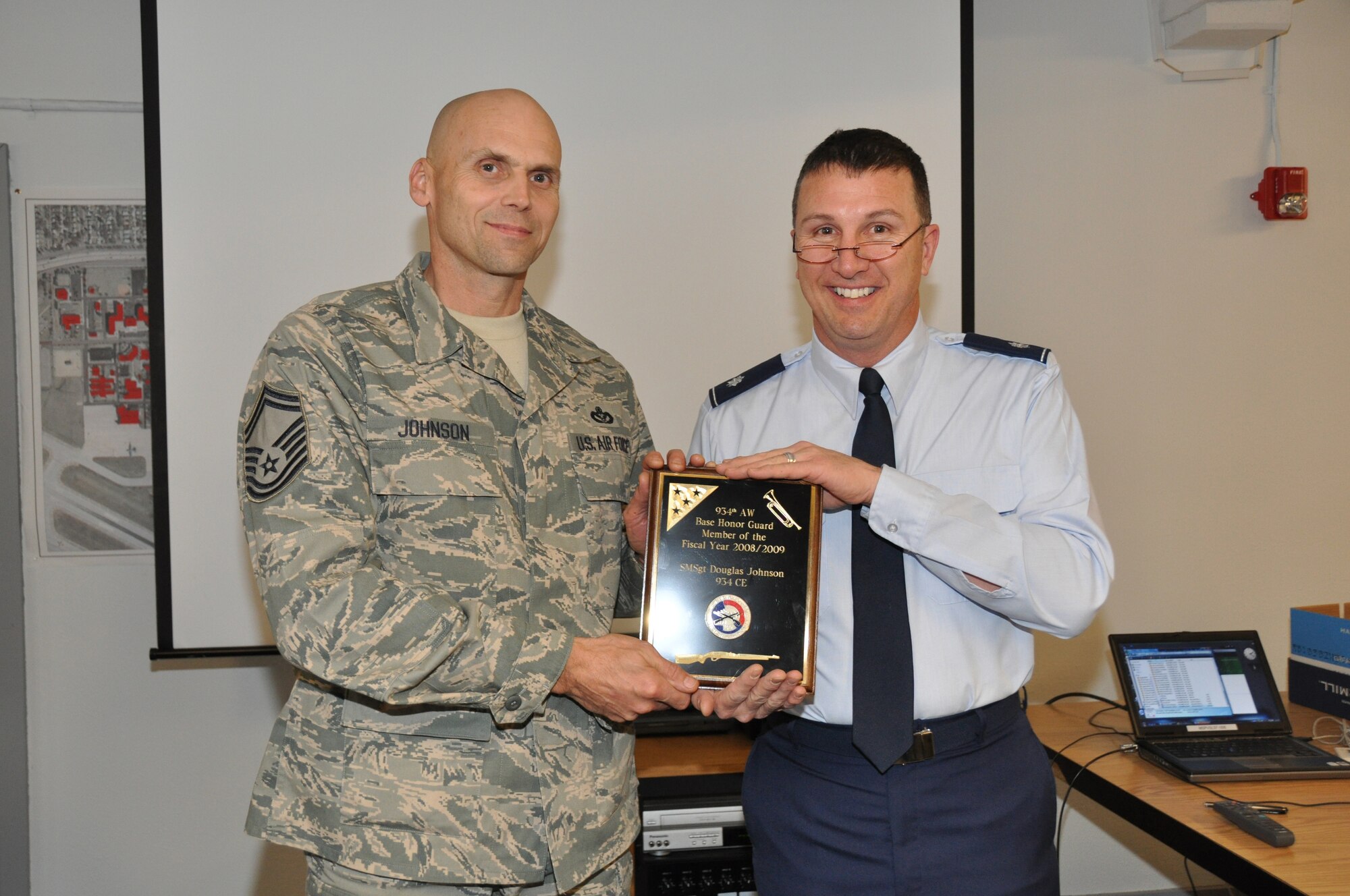 Senior Master Sgt. Doug Johnson, 934th Civil Engineer Squadron, receives the 934th Base Honor Guard Member of the Year Award from Lt. Col. Les Canarr, 934th CES commander. Sergeant Johnson performed 24 military honor funerals and five color guard details last year. He has been a member since 2002 and also performs as a bugler.(Air Force Photo/Senior Airman Noah Johnson)
