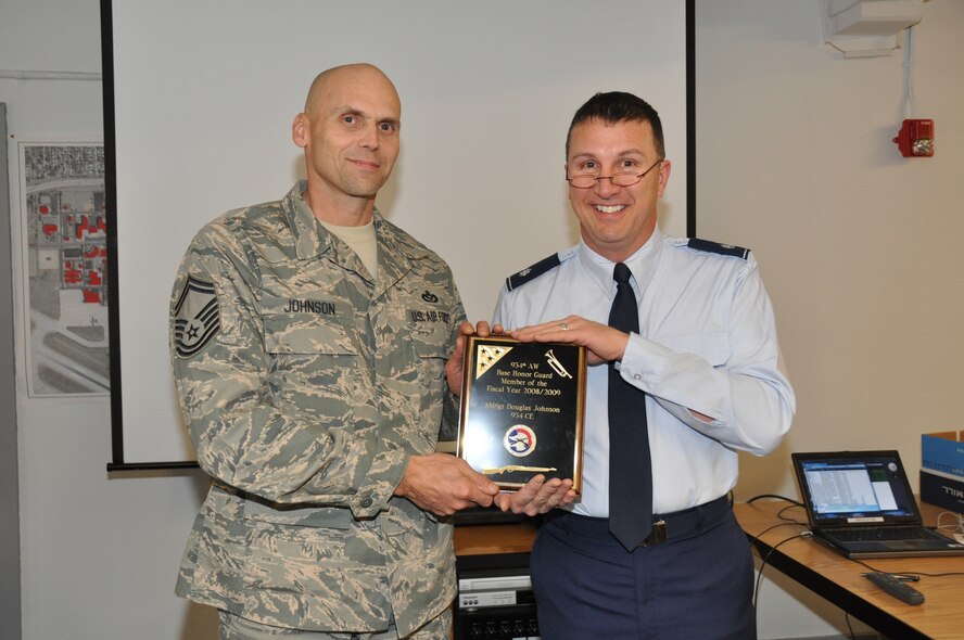 Senior Master Sgt. Doug Johnson, 934th Civil Engineer Squadron, receives the 934th Base Honor Guard Member of the Year Award from Lt. Col. Les Canarr, 934th CES commander. Sergeant Johnson performed 24 military honor funerals and five color guard details last year. He has been a member since 2002 and also performs as a bugler.(Air Force Photo/Senior Airman Noah Johnson)