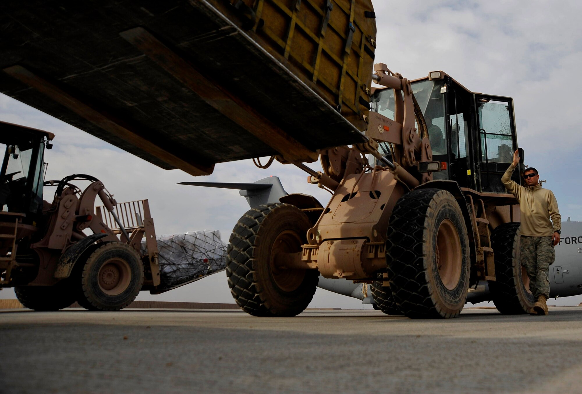 Tech. Sgt. Chris Alexander spots as pallets are unloaded from an aircraft Dec. 11, 2009, at Camp Bastion, Afghanistan. Sergeant Alexander is from the 451st Expeditionary Logistics Readiness Squadron Detachment 1. (U.S. Air Force photo/Staff Sgt. Angelita Lawrence)