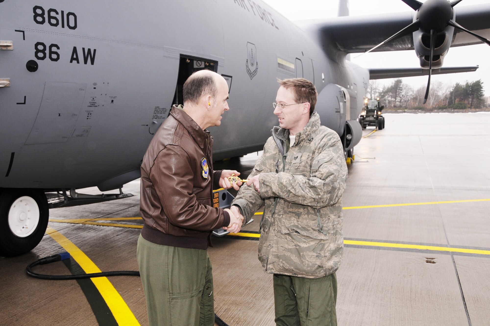 Brig. Gen. Michael Callan hands the ceremonial key to a new C-130J Super Hercules aircraft to Staff Sgt. Jason Keithley after landing the aircraft Dec. 23, 2009, at Ramstein Air Base, Germany. The J-model, one of two aircraft delivered to the 37th Airlift Squadron on the day, gives the unit a total of 10 J-models received. General Callan is the 17th Air Force Vice Commander. Sergeant Keithley is a 86th Aircraft Maintenance Squadron crew chief. (U.S. Air Force photo by Master Sgt. Jim Fisher)