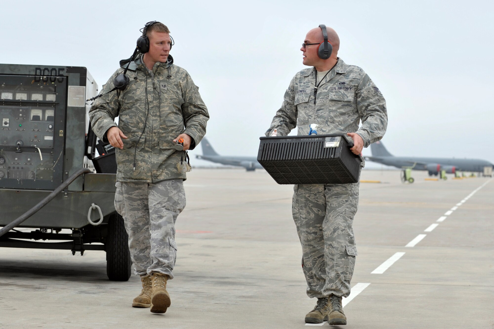 Tech. Sgt. Gregory Mitchell and Senior Airman Daniel Blondell (on right) team up while performing maintenance work on a KC-135 Stratotanker just landed at McConnell Air Force Base, Kan., by a an active-duty flight crew. Airman Blondell was one of 931st Air Refueling Group's many Reservists who filled vacancies created by deployment within the 22nd Air Refueling Wing, the 931st's active-duty host unit, in 2009. Sergeant Mitchell is a Reservist and civilian employee assigned to the 931st. (U.S. Air Force photo/Master Sgt. Jason Schaap)