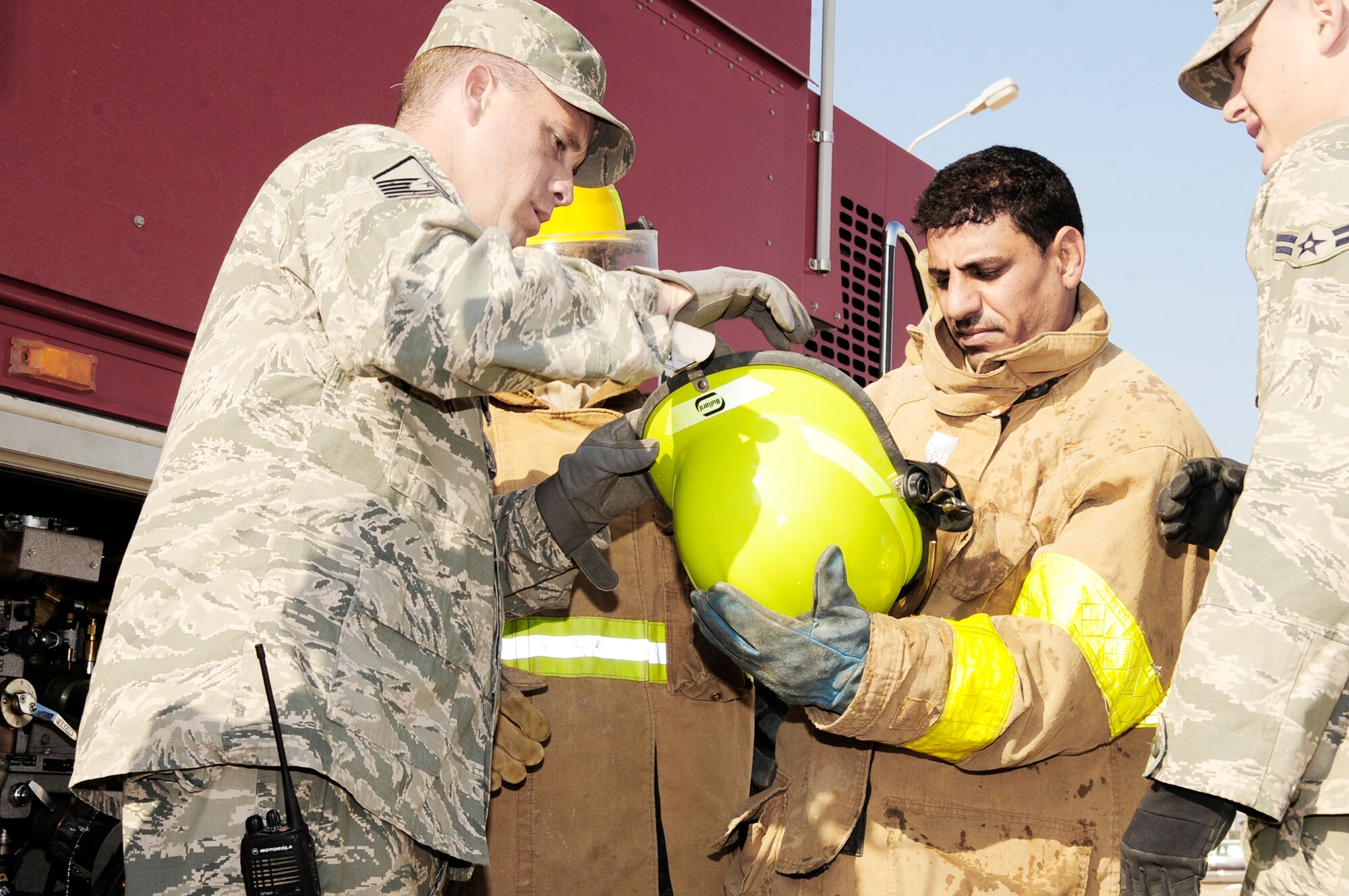 Master Sgt. Christopher Sparks, instructs an Iraqi firefighter on proper wear of personal protective equipment before a fire training exercise Dec. 28, 2009 at Camp UR, Iraq. The Airmen provide training to the Iraqi Army fire department three times a week to ensure Iraqi firefighters are self sufficient. Sergeant Sparks is from the 407th Expeditionary Civil Engineer Squadron fire department. (U.S. Air Force photo/Master Sgt. Darrell Habisch)
