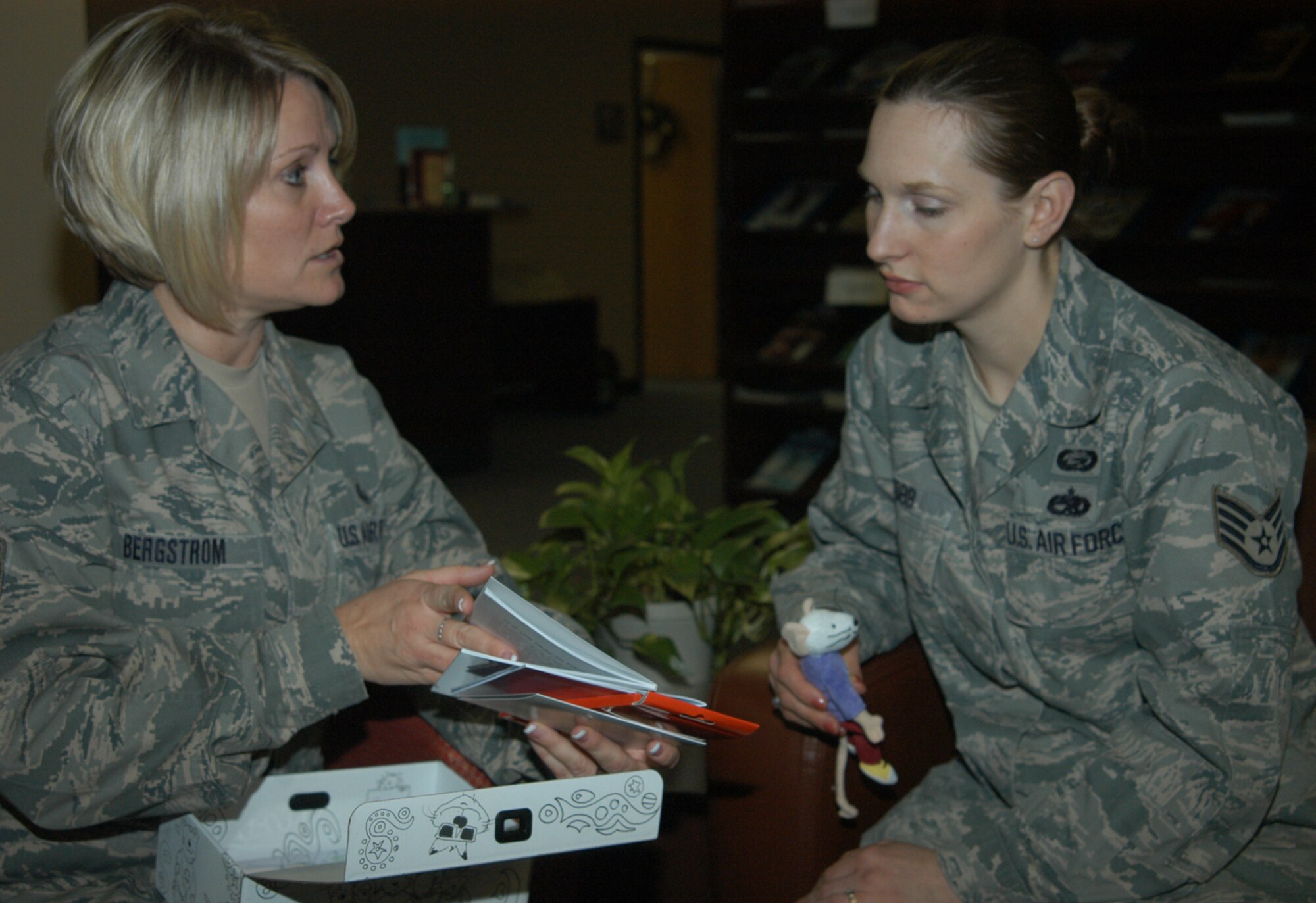 OFFUTT AIR FORCE BASE, Neb. -- Master Sgt. Stephanie R. Bergstrom (left), superintendent of the Airman and Family Readiness Center for the 55th Force Support Squadron, explains to Staff Sgt. Jessica A. Cobb (right), 55th FSS, how the contents of the "grief box" are meant to be utilized at the AFRC here Dec. 30. Along with her many responsibilities at Offutt's AFRC, Sergeant Bergstrom volunteers with the YWCA, Offutt's sexual assault prevention and response program, and teaches about 12 cardio pulmonary resuscitation classes every year. U.S. Air Force Photo by Staff Sgt. James M. Hodgman