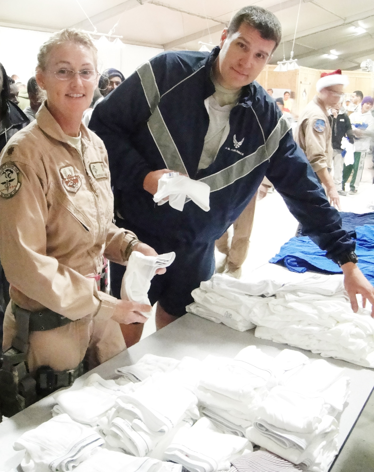 Maj. Deborah Lehker and Master Sgt. Scott Wilkes set up a table with donated supplies Dec. 17, 2009, at kandahar Airfield, Afghanistan. Sergeant Wilkes established a Wounded Warriors program in which American citizens from 37 different states sent donations to Kandahar Airfield so that servicemembers wounded in combat would have clothing available to wear during transportation. Major Lehker and Sergeant Wilkes are from the 451st Expeditionary Aeromedical Evacuation Flight. (U.S. Air Force photo/Staff Sgt. Angelique Smythe)                                