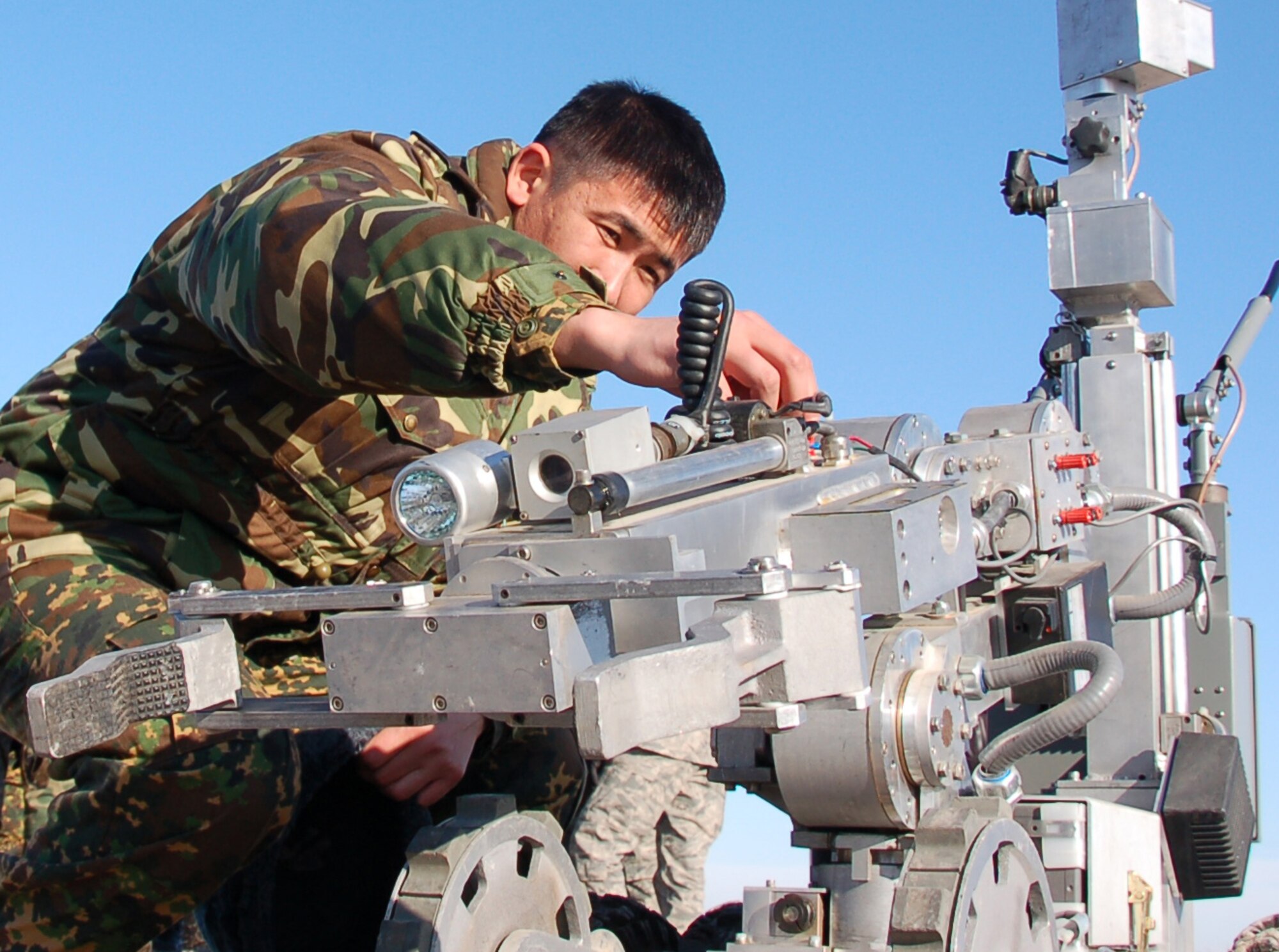 TRANSIT CENTER AT MANAS, Kyrgyzstan- Kyrgyz Capt. Nurgali Baitubaev gets a closer look at an explosive ordnance disposal robot during the Kyrgyz Ministry of Defense team’s visit to learn about EOD operations from Airmen here from Dec. 14 to Dec. 18, 2009. The five-day visit was to help the host nation build a proficient EOD team. (U.S. Air Force photo/Staff Sgt. Olufemi Owolabi)