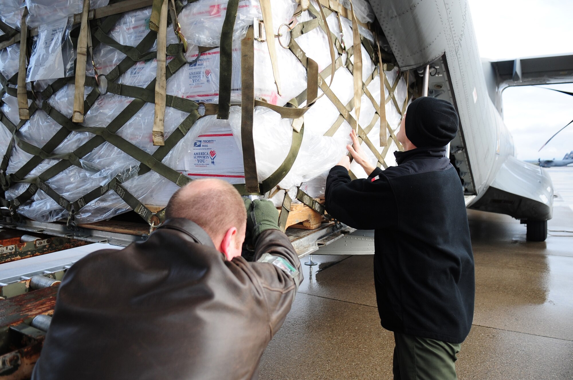 U.S. Air Force Tech. Sgt. Scott Schlup, a load master with the 37th Airlift Squadron assists a member of the Polish Air Force push a pallet onto the Polish Air Force's Casa 295 at Ramstein Air Base, Germany on Dec. 31, 2009. The pallet packed with care packages from the U.S. is to be transported to Polish troops stationed in Afghanistan. The 2,000 packages will be delivered by Polish military airlift and were donated by the American Polish Forum in the U.S. The packages contain sweets and comforts items, as well as a handwritten card and a "oplatek (OH-PWA-TEK)," a traditional
Polish wafer shared on Christmas Eve. Held under the slogan Adopt a Polish
Soldier, the care-package initiative is financed by $25 donations collected
from people across the world.  The humanitarian mission has gained the
support from foreign affairs officials both in Washington and Warsaw, with
backing from former U.S. National Security Adviser Zbigniew Brzezinski.
(U.S. Air Force photo by Staff Sgt. Jocelyn Rich) 
