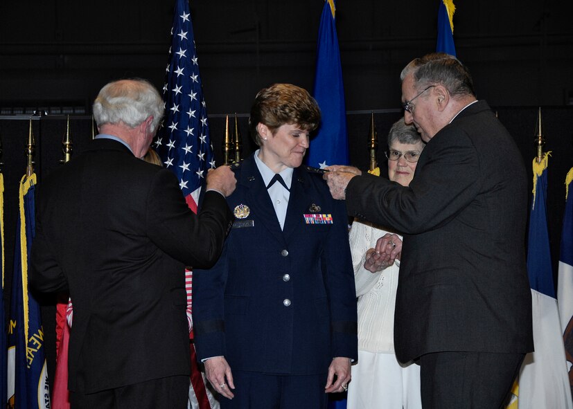 Lt. Gen. Janet C. Wolfenbarger's gets a little help from her family as they pin on her three-star rank during a promotion ceremony at the National Museum of the United State Air Force.  Approximately 20 family members of General Wolfenbarger were present for the Dec. 30 ceremony, which also celebrated the general's newly confirmed position as AFMC vice commander. (U.S. Air Force Photo/Mike Libecap) 
