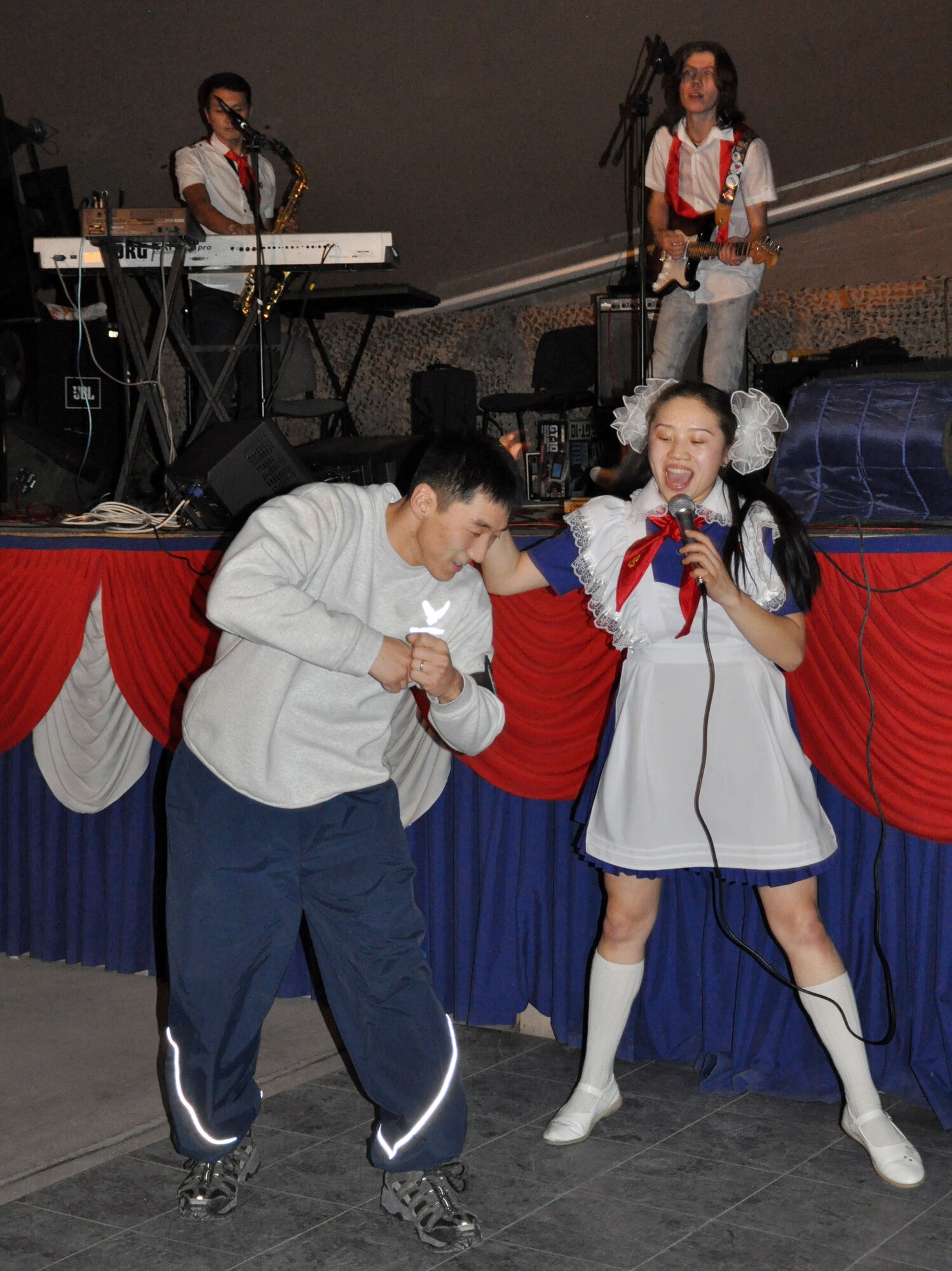 TRANSIT CENTER AT MANAS, Kyrgyzstan – Staff Sgt. Chae Pak, 376th Expeditionary Civil Engineer Squadron, dances with Arttec, a local band, at Pete’s Place here Dec. 30, 2009. The 376th Expeditionary Force Support Squadron hosted this top-rated band from Bishkek, Kyrgyzstan. Frequent morale events occur here to entertain Airmen, Soldiers, Sailors, and Marines deployed in support of Operation Enduring Freedom and the International Security Assistance Force helping to promote regional stability in Central Asia. Sergeant Pak is deployed from the 718th Civil Engineer Squadron, Kadena Air Base, Okinawa, Japan. (U.S. Air Force photo/ Staff Sgt. Carolyn Viss)
