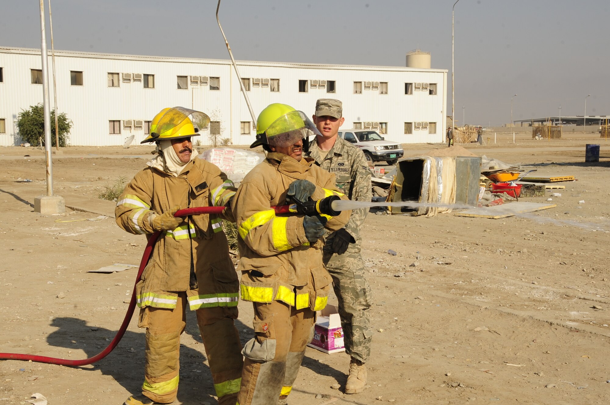 CAMP UR, Iraq - Airman 1st Class Sean Piper, 407th Expeditionary Civil Engineer Squadron fire department, provides fire training to Iraqi firefighters, Dec. 28, 2009.  The Airmen provide training to the Iraqi Army fire department three times a week to ensure Iraqi firefighters are self sufficient.  (U.S. Air Force photo/Master Sgt. Darrell Habisch) 