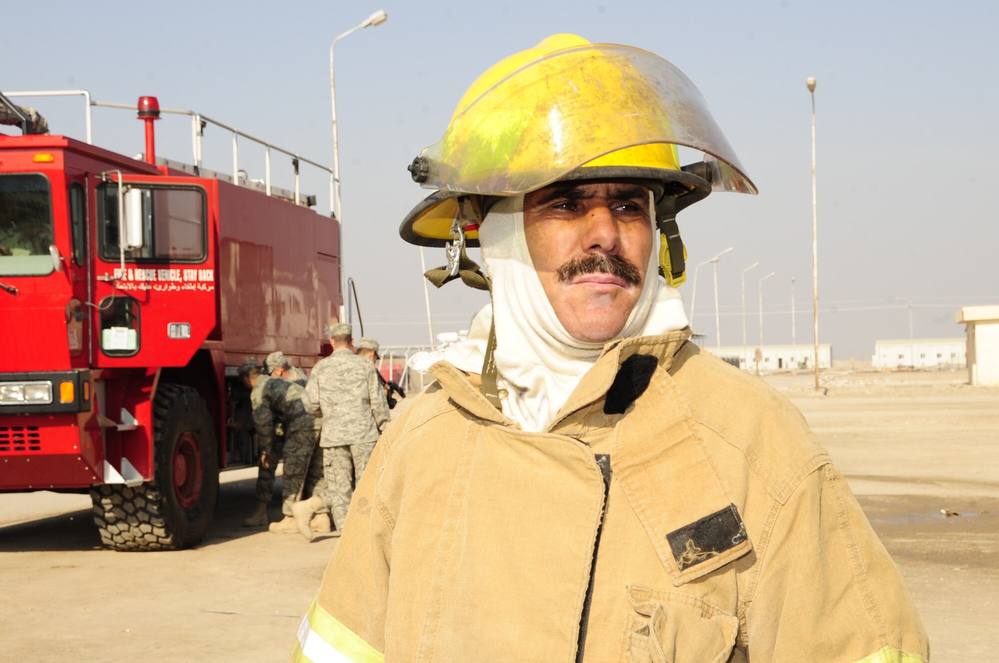 CAMP UR, Iraq - Aziz, an Iraqi Army Warrant Officer and Fire Chief, looks on during fire training provided by members of the 407th Expeditionary Civil Engineer Squadron fire department, Dec. 28, 2009.  The Airmen provide training to the Iraqi Army fire department three times a week to ensure Iraqi firefighters are self sufficient.  (U.S. Air Force photo/Master Sgt. Darrell Habisch) 