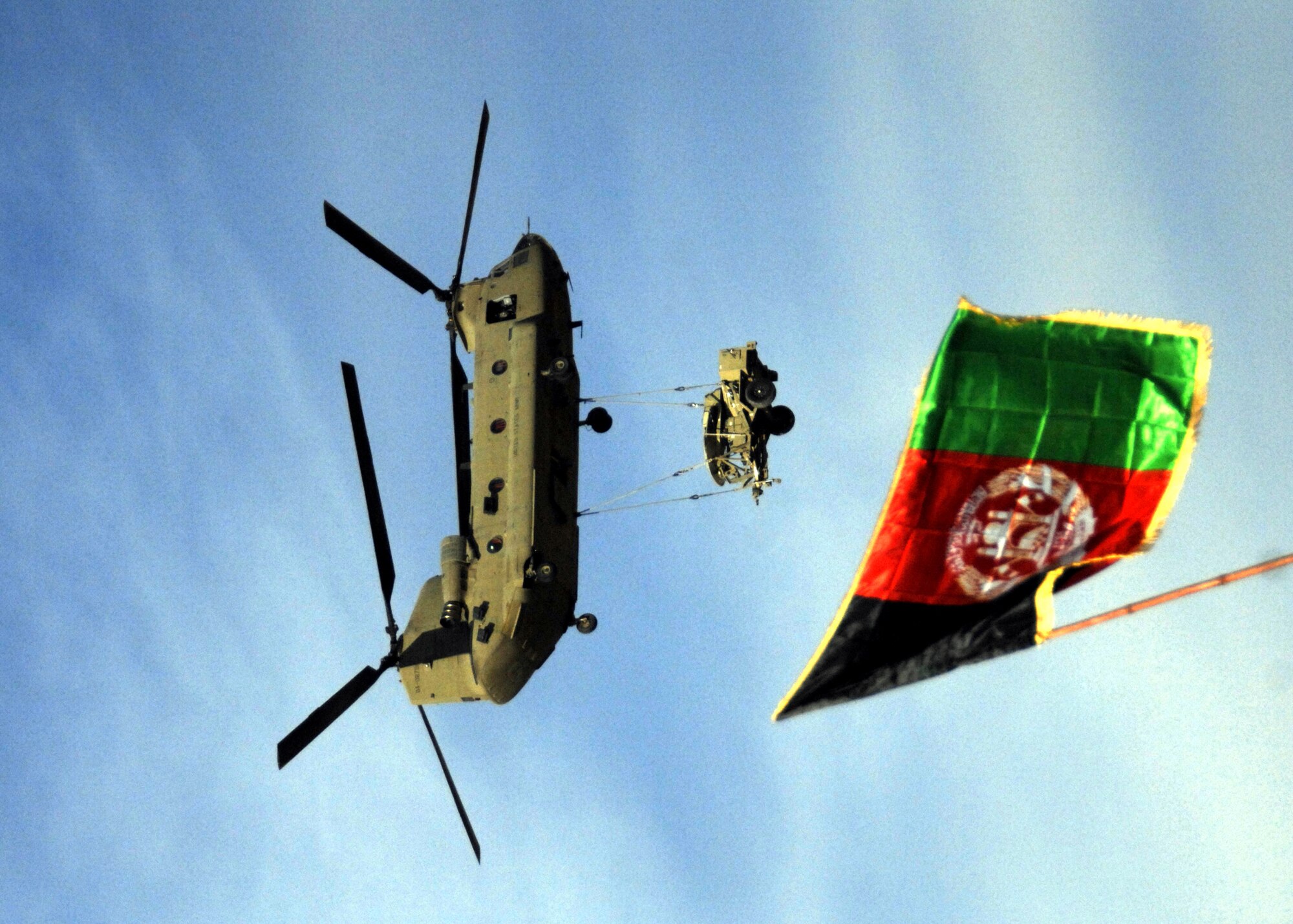 ZABUL PROVINCE, Afghanistan -- A U.S. Army helicopter flies over Afghanistan's flag on Dec. 26.  Afghans celebrated the Arghandab Bridge opening, Dec. 26, 2009. The bridge provides access to the northern part of the province, allowing people to transport food and supplies during winter months as water levels are high during that season.  The bridge is also important to security in the winter and spring months when forces were previously limited to being supported by helicopter due to high water levels. (U.S. Air Force photo/Senior Airman Timothy Taylor)