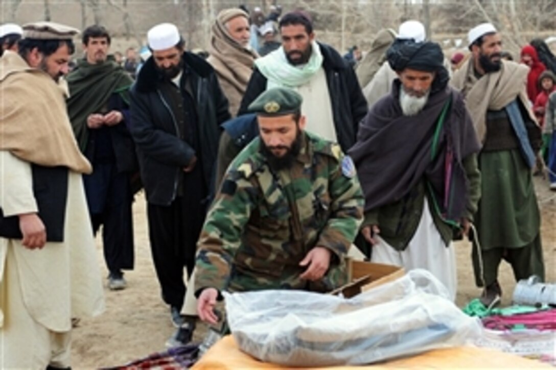 An Afghan soldier unloads supplies during a civil assistance mission in Gardez in Afghanistan's Paktya province, Dec. 29, 2009. Both U.S. and Afghan soldiers combined efforts to bring blankets, cooking stoves, food items, shoes and winter jackets to local citizens. The U.S. soldiers are assigned to Forward Operating Base Lightning.
