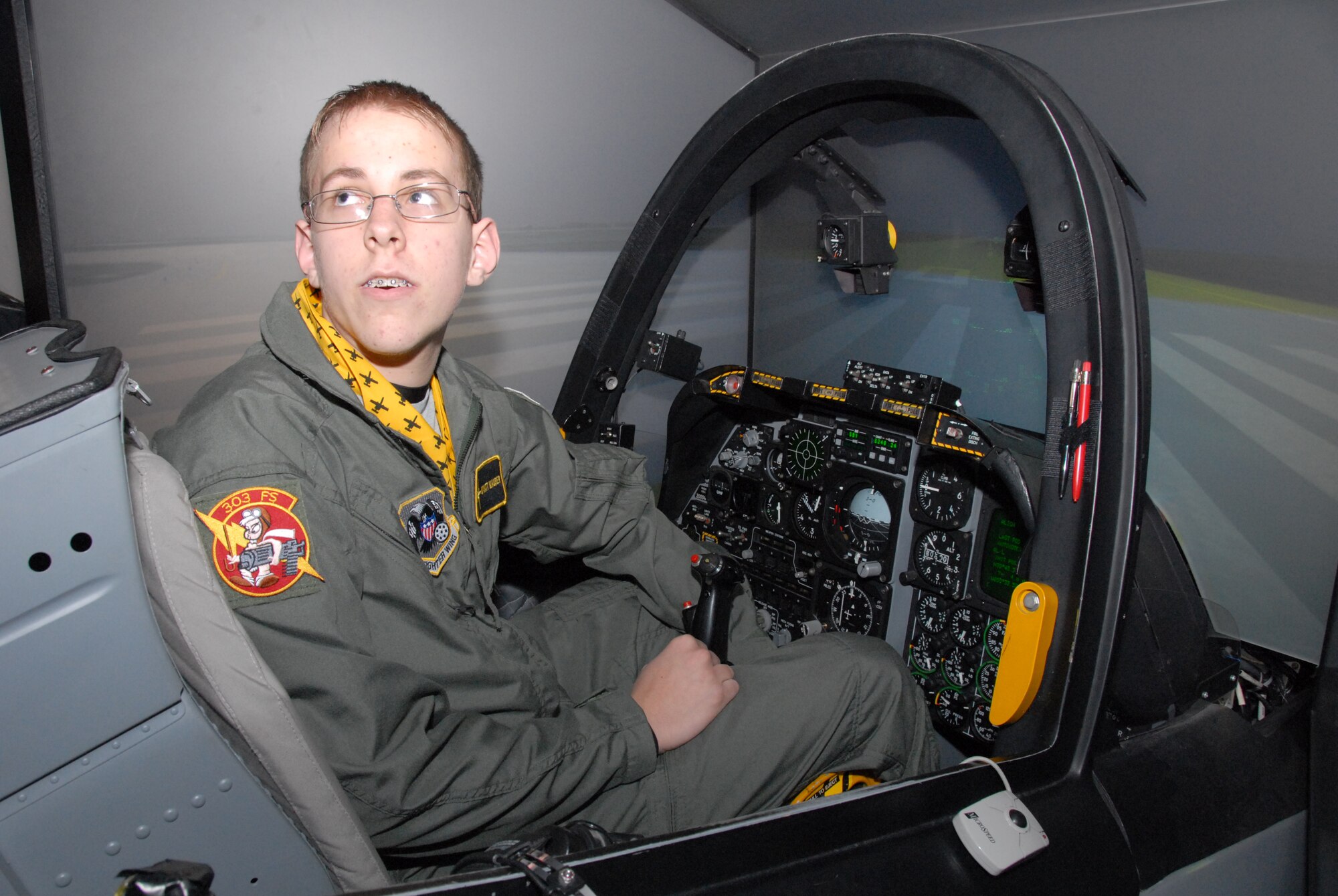 Thirteen-year-old Wyatt Maurer, asks a question to Capt. Chad Rogers, 303rd Fighter Squadron A-10 pilot, while at the controls of the squadron's A-10 Thunderbolt II simulator during his "pilot for a day" experience at the 303rd Jan. 11.  Not only was Wyatt  treated to a simulator "ride" but also received a tour of an actual A-10 and a day in the life of an A-10 pilot.  The visit was made possible by the Greater Kansas City chapter of the Dream Factory, which arranges special memories for children with serious or chronic medical conditions.  The 303rd is part of the 442nd Fighter Wing, an Air Force Reserve Command unit based at Whiteman Air Force Base, Mo.  (U.S. Air Force photo/Maj. David Kurle)