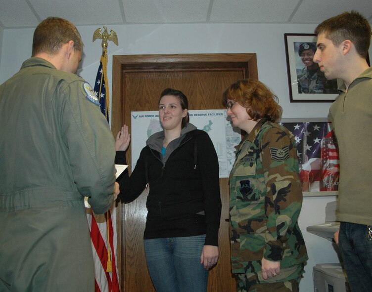 NIAGARA FALLS AIR RESERVE STATION, N.Y. - Airman 1st Class Dana Humphrey receives the oath of enlistment into the Air Force Reserve from 1st Lt. Jamie Gilkerson as Tech. Sgt. Karen Humphrey, Dana' s mother and now fellow 914th Airlift Wing member, looks proudly on.  Family friend Airman 1st Class Patrick Debo, who recently enlisted October 30, was in attendance as well and both friend and daughter were brought into the Air Force Reserve through the Get One Now program by Tech. Sgt. Humphrey.  (U.S. Air Force photo by Tech. Sgt. Kevin Nichols)