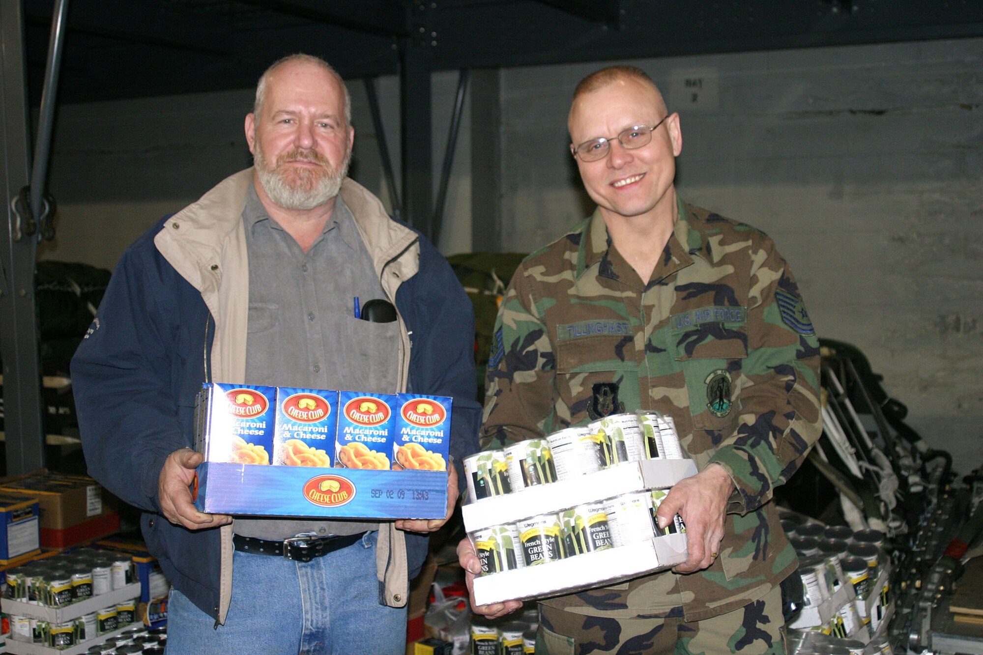 NIAGARA FALLS AIR RESERVE STATION, N.Y. -- For the fourth year in a row, Tech. Sgt. Phil Tillinghast (right) has collected thousands of non-perishable foods for donation to needy families near Niagara Falls ARS at year's end. A cargo processing technician for the 30th Aerial Port Squadron here, Sgt. Tillinghast's 'Christmas Cargo' covered much of the the floor of the squadron building during the unit's annual holiday party Dec. 6, 2008. His long-time friend and civilian coworker Mr. Ronald Shaw (left) helped make it happen for the last two years.  (U.S. Air Force Photo by Mr. Mike Harvey)
