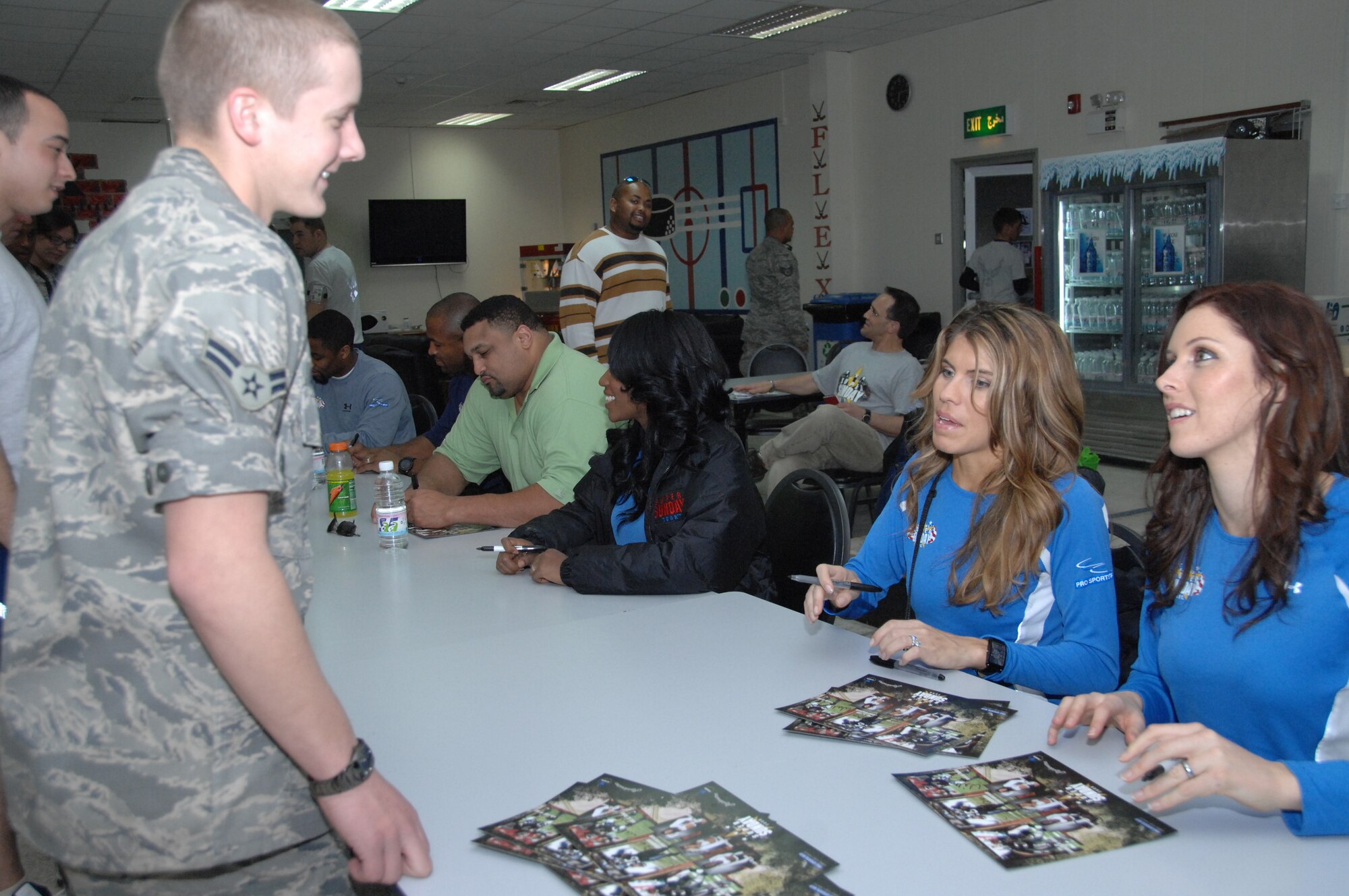 SOUTHWEST ASIA -- Ariel Ogilvie, Raider cheerleader, personalizes an autograph for an Airman stationed at an air base in Southwest Asia, Jan. 31. 3 NFL stars along with three Raiderettes signed autographs for Airmen and Soliders during their U.S. Army Super Sunday tour. (U.S. Air Force photo/Senior Airman Courtney Richardson)