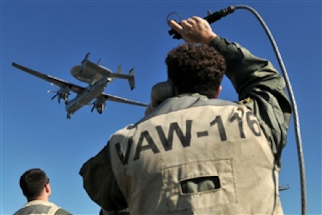U.S. Navy Lt. David Berry monitors an E-2C Hawkeye aircraft, Jan. 28, 2009, while acting as landing signal officer on the flight deck of USS Abraham Lincoln. The ship is under way in the Pacific Ocean conducting sustainment training and carrier qualifications. Berry is assigned to Airborne Early Warning Squadron 116.