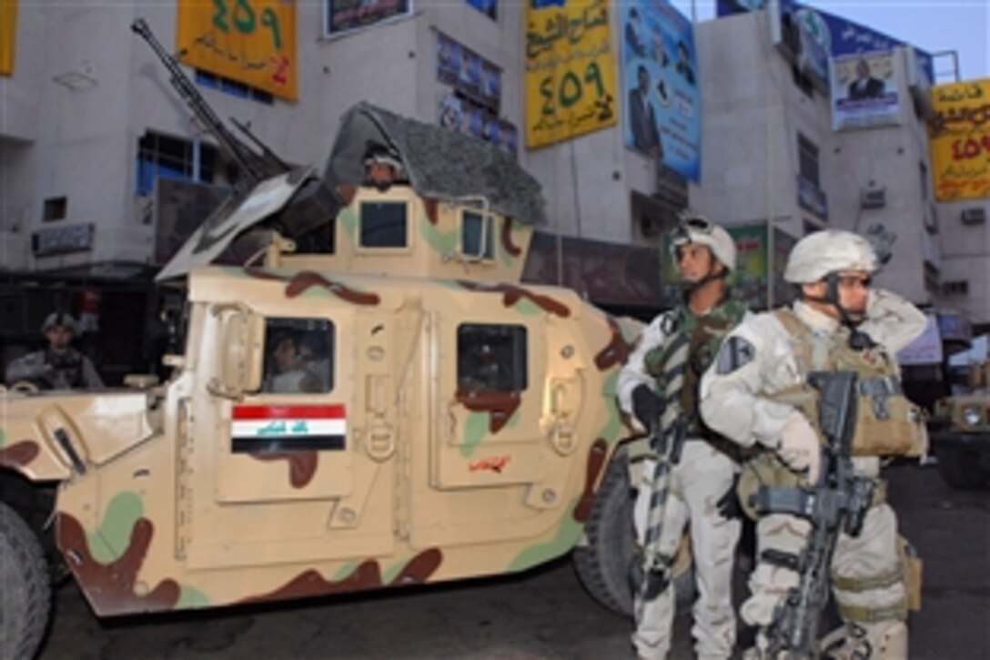 U.S. Army soldiers stand by to provide support to Iraqi army troops manning a checkpoint in Baghdad’s Sadr City district, Jan. 31, 2009. The Iraqi government held provincial elections in which 14,400 candidates competed for 440 seats in 14 of 18 Iraqi provinces.