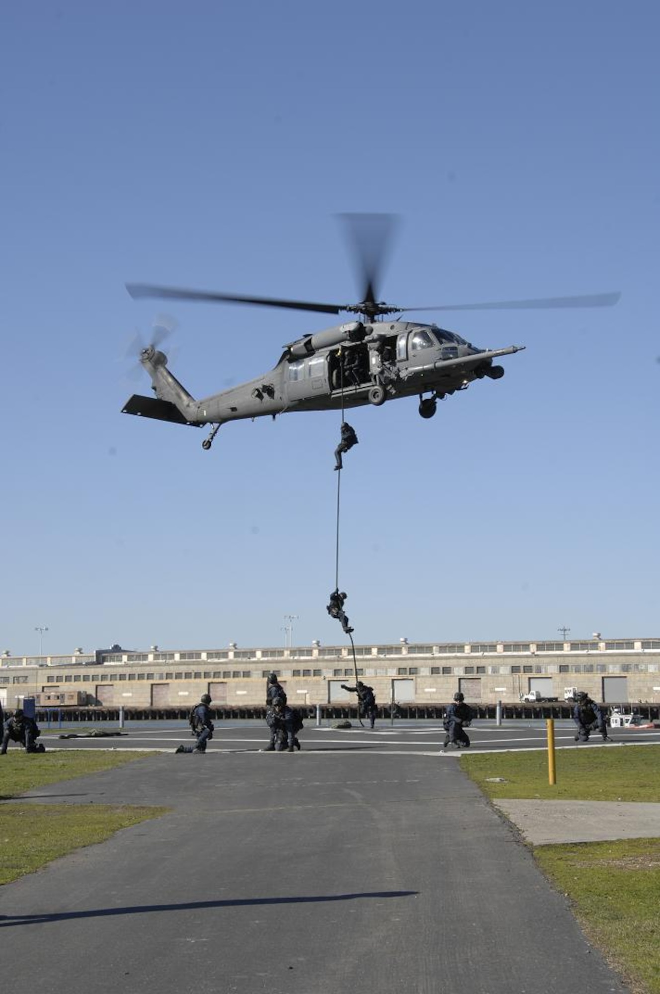 Members of the U. S. Coast Guard Maritime Search and Security Team 91105 descend from a 129th Rescue Wing-based HH-60G Pave Hawk at Coast Guard Island, Calif., Jan. 29.  The Crewmembers conducted vertical insertion training, which is a fast-paced technique used to effectively deploy a law enforcement team to a high-risk situation. Shortly after the training was completed, the 129th RQW and Coast Guard crews rescued a downed pilot near Pillar Point, Calif. (U.S. Air Force photo by Tech Sgt. Ray Aquino)