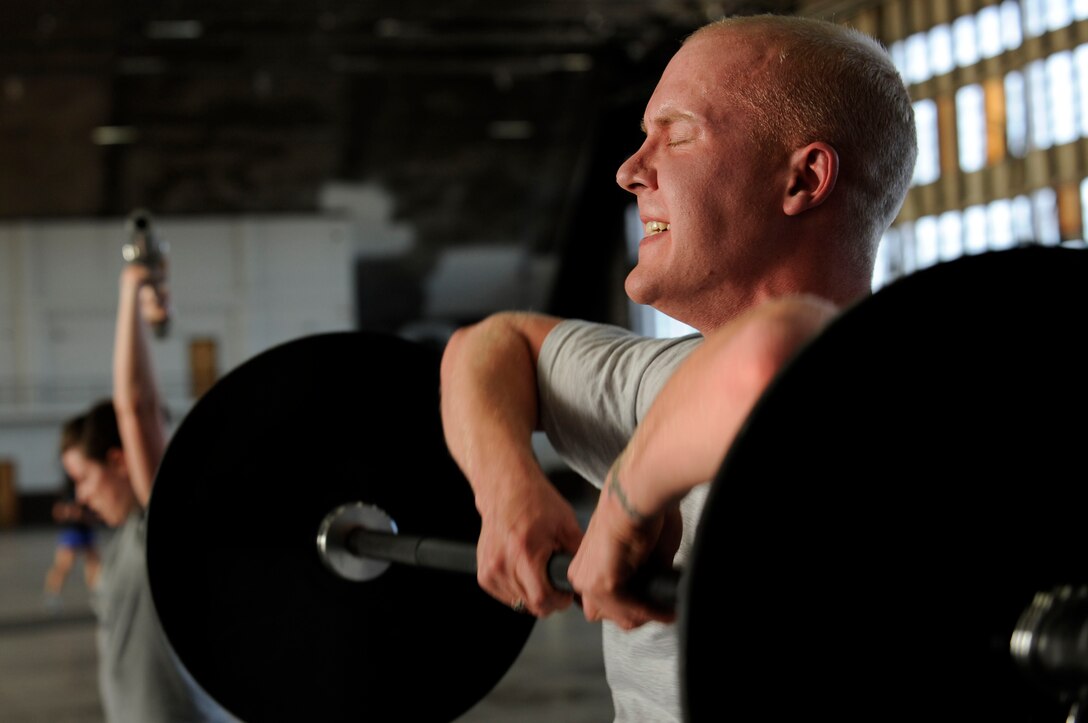 Senior Airman Marc Lane, 28th Bomb Wing Public Affairs still photographic journeyman, performs a deadlift high-pull during the Fight Gone Bad crossfit tournament here, Jan. 30. The Fight Gone Bad workout mimics mixed-martial arts training and consists of five exercises, performed for one minute each, with one-minute breaks given after all exercises have been completed. (US Air Force photo/Airman 1st Class Corey Hook)
