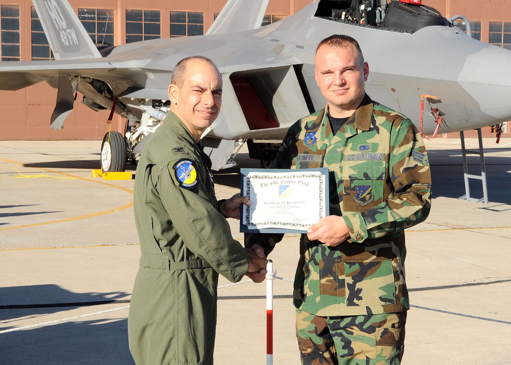 49th Fighter Wing commander, Col. Jeff Harrigian, presents a certificate of recognition to Senior Airman Chad Eichmeier, 49th Aircraft Maintainance Squadron, at the Load Crew of the Year competition at Holloman Air Force Base, N.M., Jan. 30. Airman Eichmeier was being recognized for the effort given at the competition. (U.S Air Force photo/ Airman 1st Class DeAndre Curtiss)