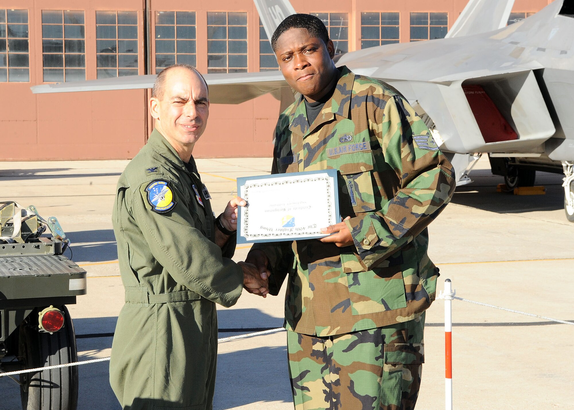 49th Fighter Wing commander, Col. Jeff Harrigian, presents a certificate of recognition to Staff Sgt. Ernest Fishburne, 49th Aircraft Maintainance Squadron, at the Load Crew of the Year competition at Holloman Air Force Base, N.M., Jan. 30. Sergeant Fishburne as being recognized for the effort given at the competition. (U.S Air Force photo/ Airman 1st Class DeAndre Curtiss)