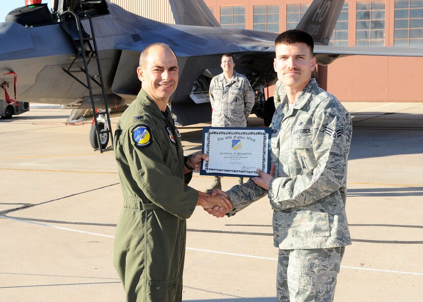 49th Fighter Wing commander, Col. Jeff Harrigian, presents a certificate of recognition to Senior Airman Steven Johnson, 49th Aircraft Maintainance Squadron, at the Load Crew of the Year competition at Holloman Air Force Base, N.M., Jan. 30. Airman Johnson was being recognized for the effort given at the competition. (U.S Air Force photo/ Airman 1st Class DeAndre Curtiss)
