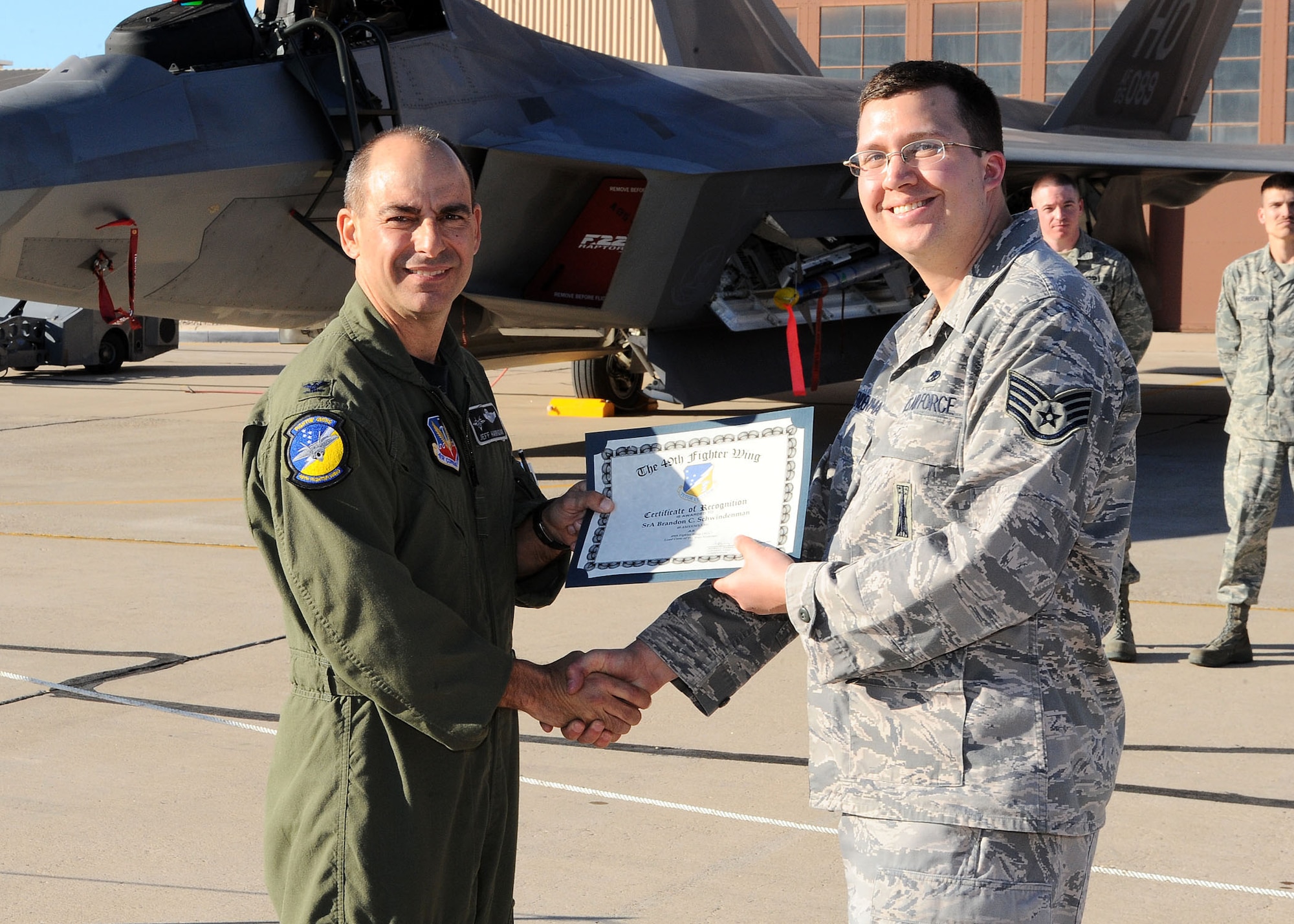 49th Fighter Wing commander, Col. Jeff Harrigian, presents a certificate of recognition to Staff Sgt. Brandon Schwendenman, 49th Aircraft Maintainance Squadron, at the Load Crew of the Year competition at Holloman Air Force Base, N.M., Jan. 30. Sergeant Schwendenman was being recognized for the effort given at the competition. (U.S Air Force photo/ Airman 1st Class DeAndre Curtiss)