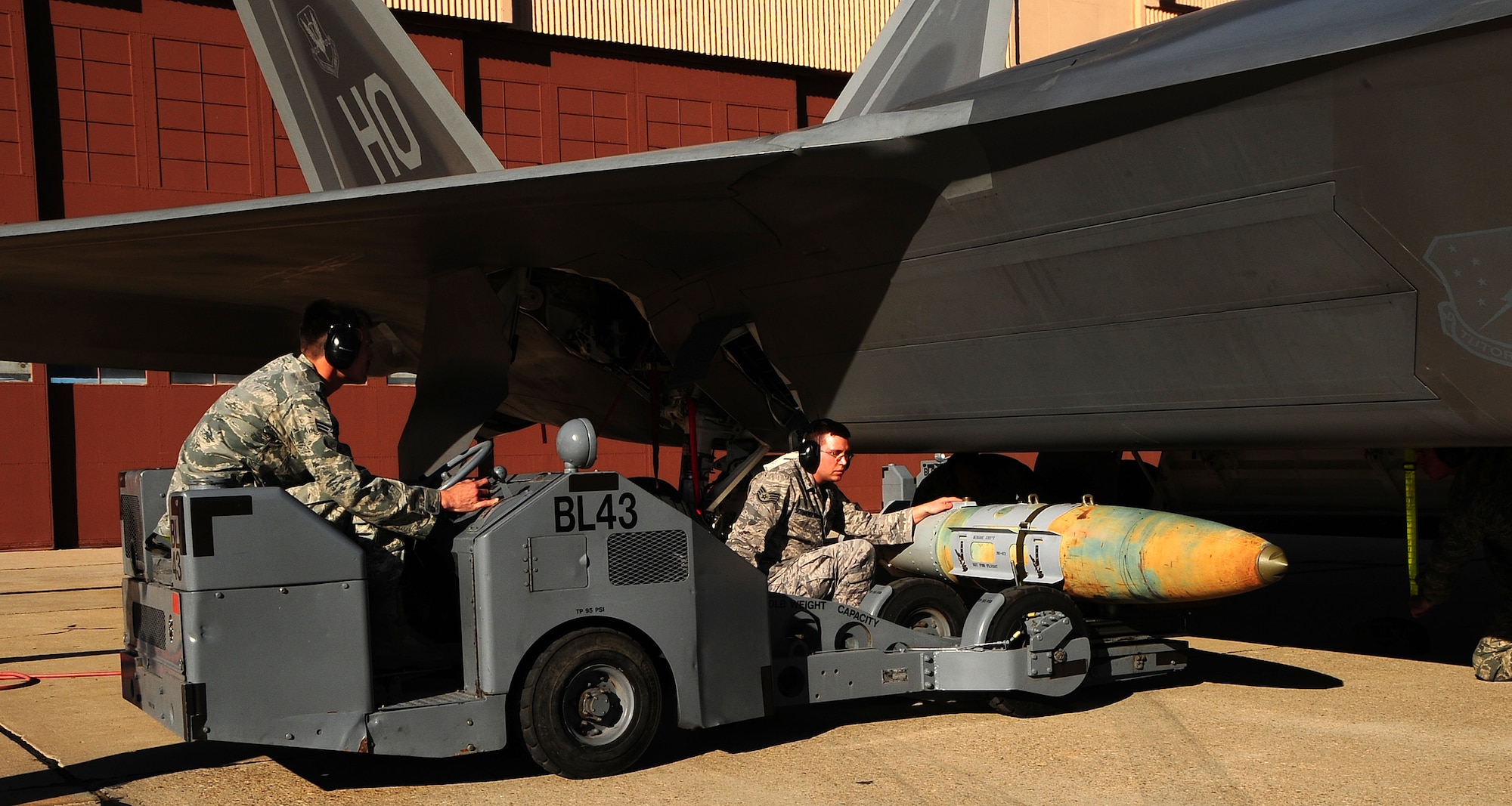 Senior Airman Steven Johnson and Staff Sgt. Brandon Schwendenman load an F-22A Raptor at the Load Crew of the Year competition at Holloman Air Force Base, N.M., Jan. 30. (U.S. Air Force photo/Tech. Sgt. Chris Flahive)
