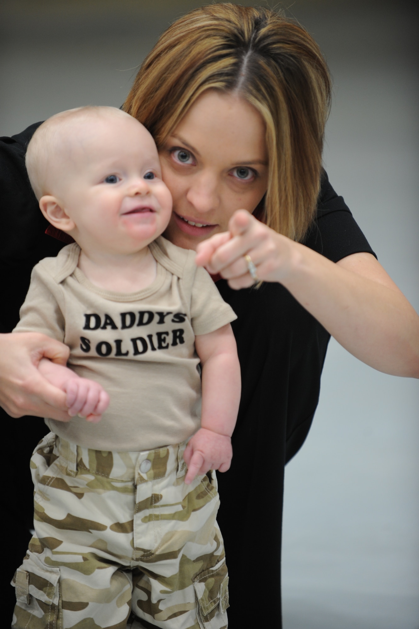 Melissa Stetser, points as her son, Eian, stares as his father Staff Sgt. Keith Stetser, 28th Maintenance Squadron weapons system operator craftsman, arrives home from a six-month deployment to Southwest Asia here, Jan. 31. While deployed, Sergeant Stetser maintained the combat readiness of B-1B Lancers. (U.S. Air Force photo/Airman 1st Class Adam Grant)