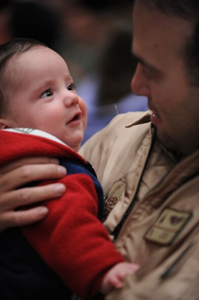 Capt. Joseph Colt, 34th Bomb Squadron flight surgeon, hugs his son upon return from a six-month deployment to Southwest Asia here, Jan. 31. Deployed Ellsworth Airmen provided rapid, decisive and sustainable combat airpower to the theatre commander. (U.S. Air Force photo/Airman First Class Adam Grant)
