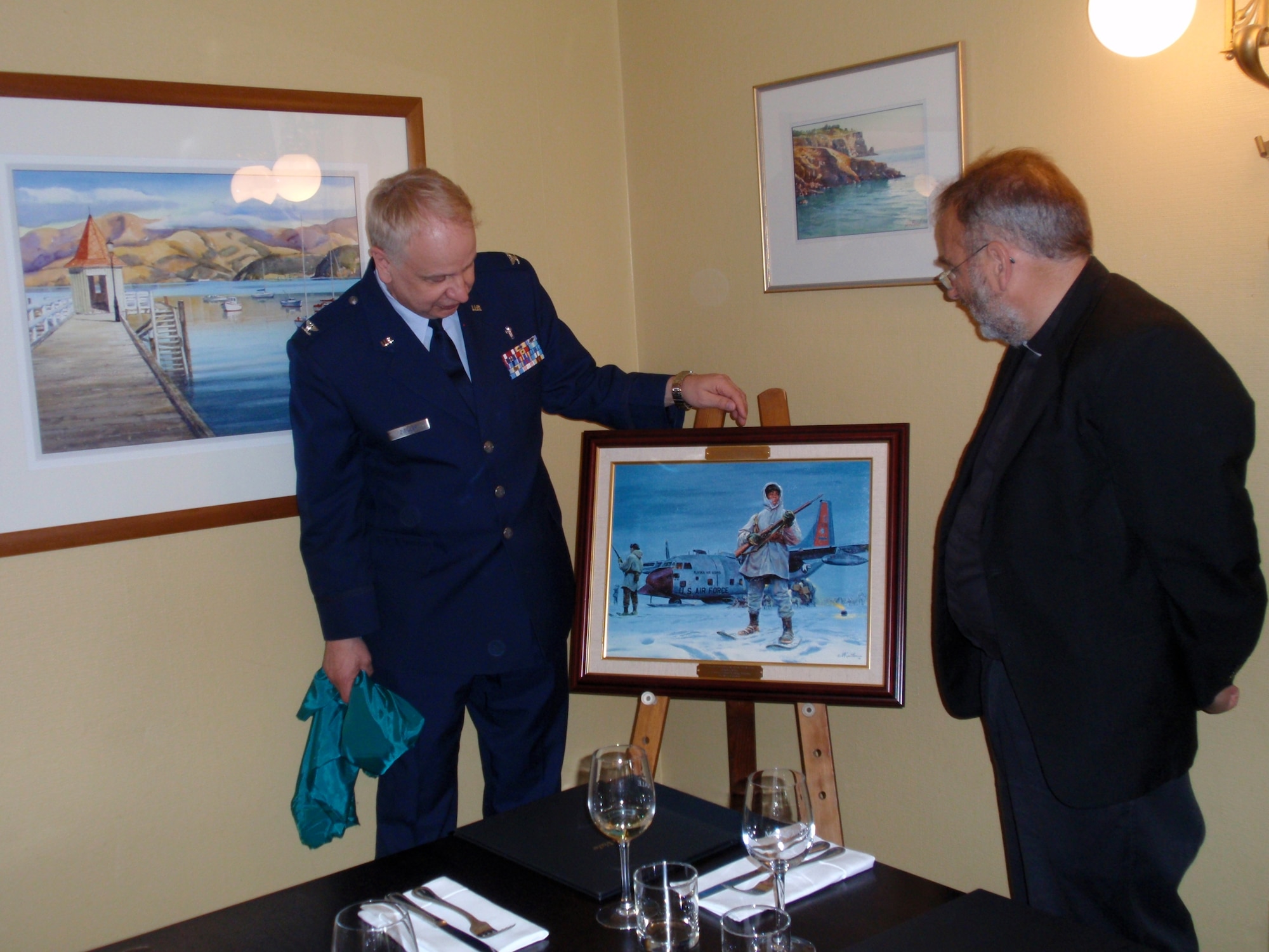The National Guard Heritage Painting by Mort Kunstler entitled "Guardians of the North" featuring a ski-equipped LC-130 Hercules, similar to those flown by the Department of Defense forces supporting the U.S. Antarctic Program as part of Operation Deep Freeze, is presented to the Roman Catholic Diocese of Christchurch, New Zealand, Jan. 27 by Col. William Ziegler, Office of the Command Chaplain, Pacific Air Forces. 