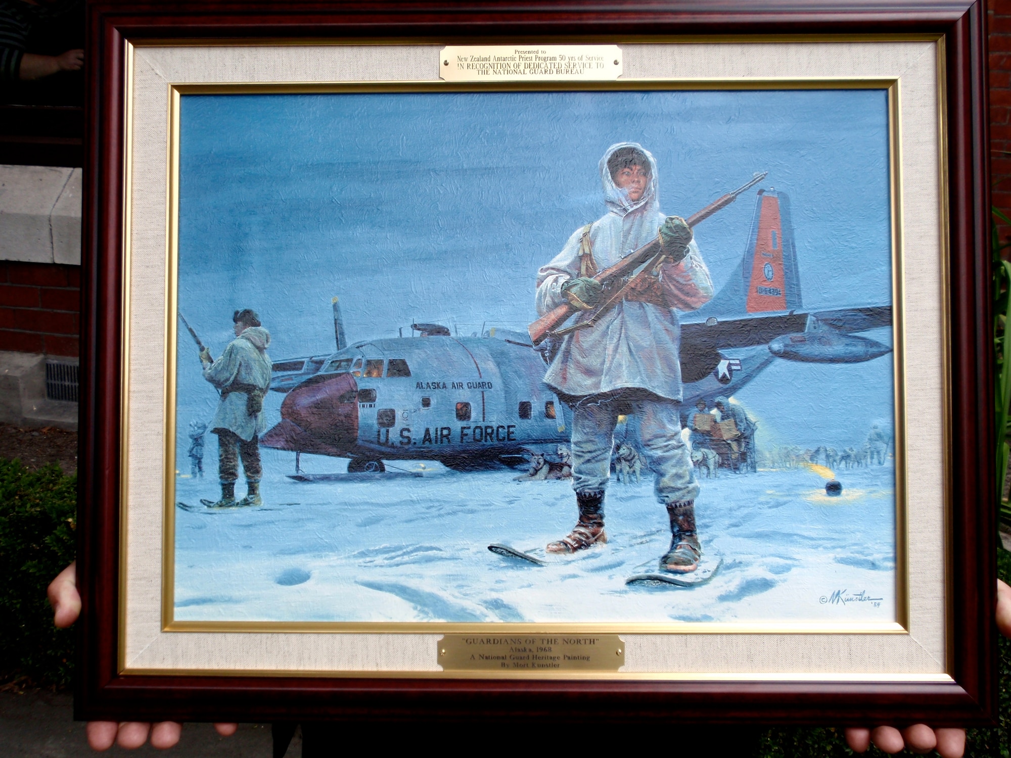 The National Guard Heritage Painting by Mort Kunstler entitled "Guardians of the North" featuring a ski-equipped LC-130 Hercules, similar to those flown by the Department of Defense forces supporting the U.S. Antarctic Program as part of Operation Deep Freeze, is presented to the Roman Catholic diocese of Christchurch, New Zealand, Jan. 27. 
