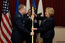 HANSCOM AIR FORCE BASE, Mass. - Col. Jeffrey Mayo (left), 66th Air Base Wing vice commander, passes the guidon flag to Sara Mattes, Town of Lincoln selectman, marking her induction into the Hanscom Honorary Commander program on Jan. 30. Ms. Mattes will serve a two-year term as Honorary Vice Commander for the 66th Air Base Wing. The Honorary Commander program is designed to educate participants as well as build and improve relationships with local civic and community leaders by providing greater access to Air Force commanders, programs, personnel and operations. (U.S. Air Force photo by Mark Wyatt)