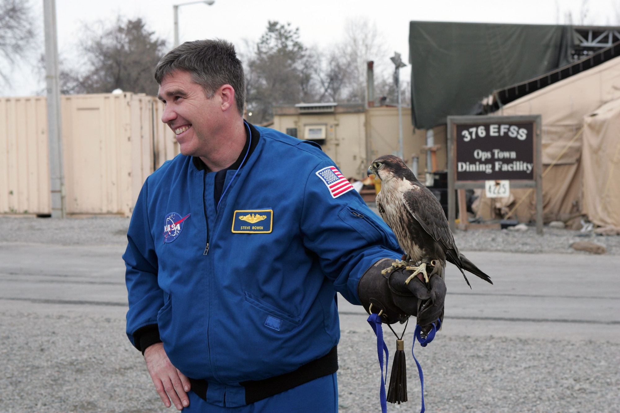 Navy Capt. Steve Bowen, a NASA astronaut, poses for a picture with Mustang, one of two falcons trained to keep birds away from the airfield, during a tour of Manas Air Base, Kyrgyzstan, Jan. 28. The crew of the Space Shuttle Endeavour STS-126 mission visited with Airmen and local Kyrgyz school children during their two-day visit here. (U.S. Air Force photo/Tech. Sgt. David Jones)