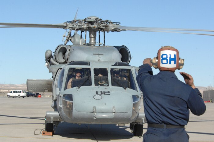 NELLIS AIR FORCE BASE, Nev. – U.S. Navy plane captain Airman Joshua Cooley, Helicopter Support Combat Squadron 85, North Island, San Diego, CA, marshals in a Navy HH-60 here Jan. 29 after landing from a mission for RED FLAG 09-2.  RED FLAG is a multinational exercise providing a realistic environment to practice combat scenarios.  The experience gained during the exercise is vital to the survival of the pilots in combat. 