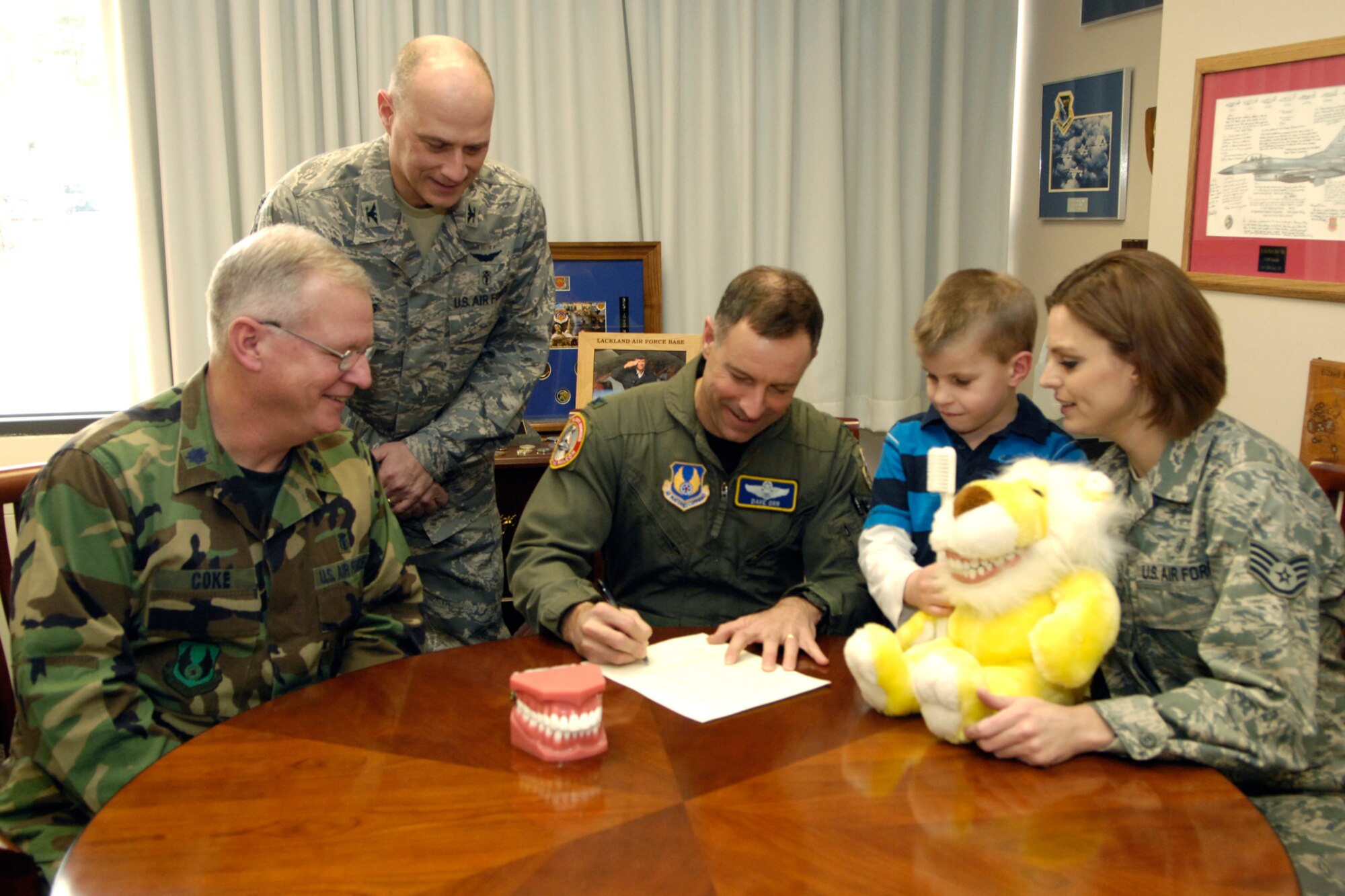 Lt. Col. (Dr.) John Coke, 66th Dental Flight commander; Col. Randy Dobbins, 66th Medical Group commander; Brendin Duncan and Staff Sgt. Kristin Hays, registered dental hygienist, look on as  Col. Dave Orr, 66th Air Base Wing commander, signs a proclamation declaring February National Children's Dental Health Month on Hanscom.  (U.S. Air Force photo by Mark Wyatt) 