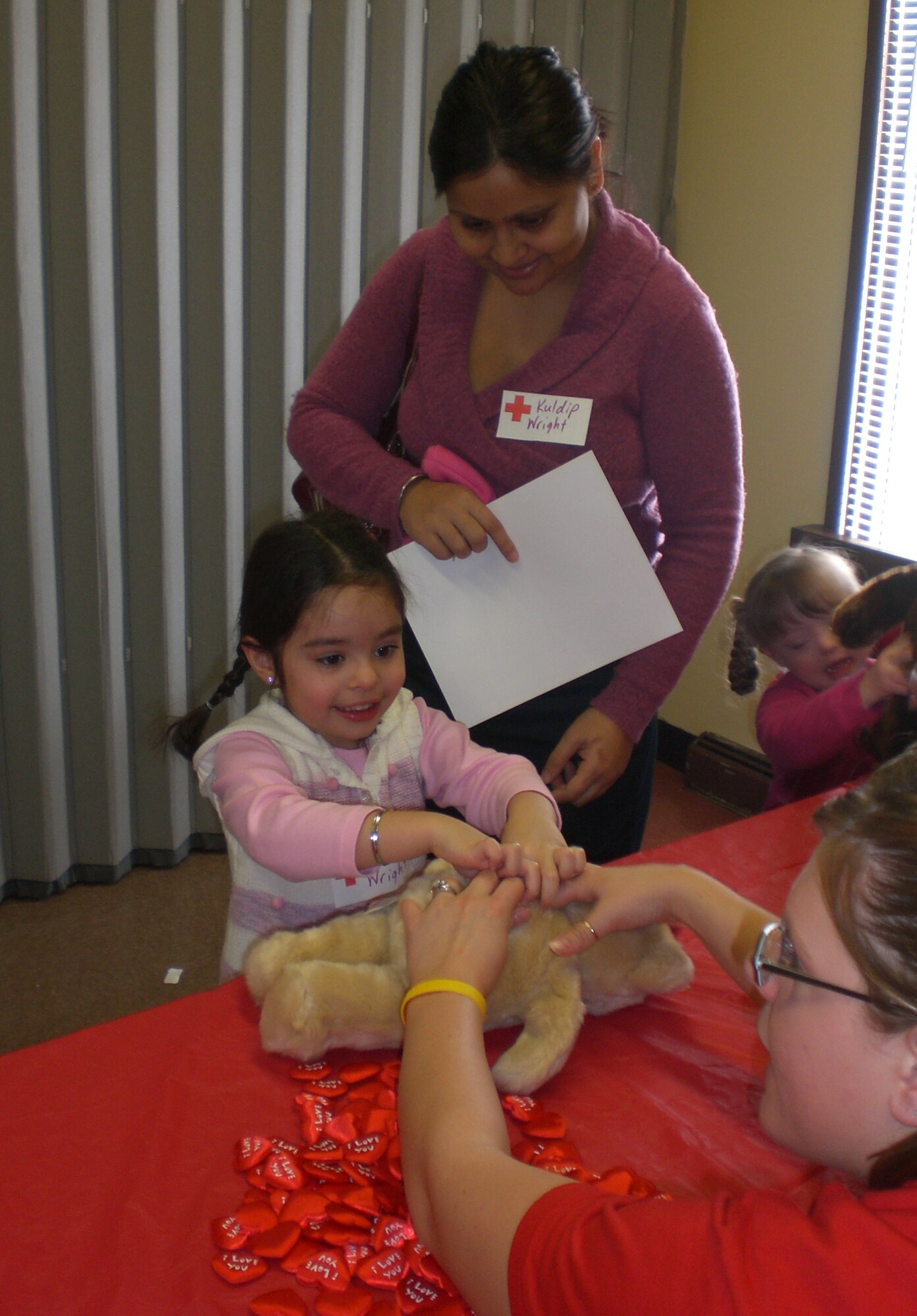 A Build-A-Bear volunteer assists Anika Wright in giving her bear a loving heart during a Pre-deployment Fair for base Airmen and their families Jan. 31 at Wright-Patterson Air Force Base. Nearly 200 participated in the event, designed to ease the stress of deployment for military families. Anika is the daughter of Kuldip and Maj. Joshua Wright, an 88th Medical Group physician deployed to Afghanistan. (U.S. Air Force photo/Derek Kaufman)