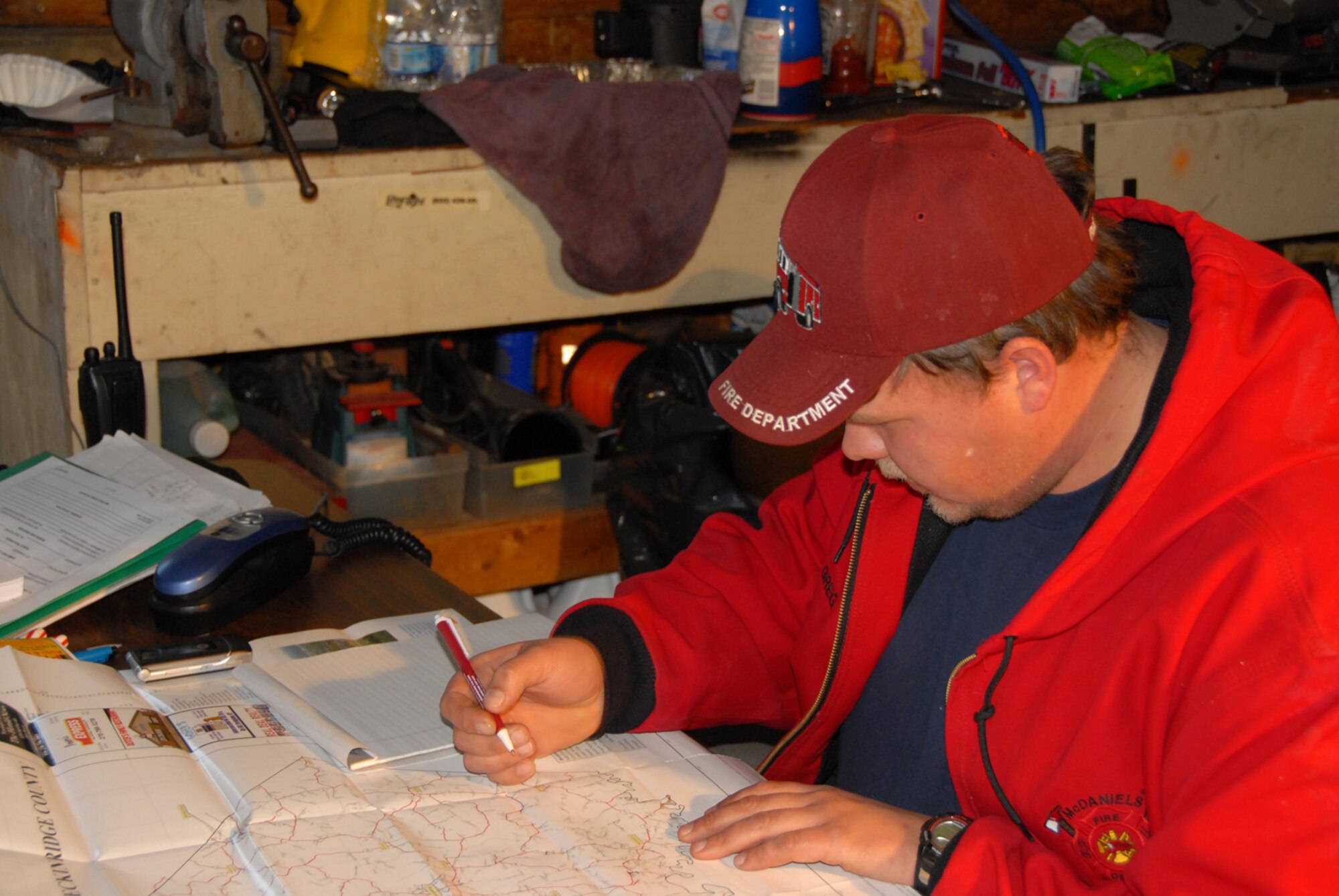 A member of the McDaniels Fire Department plots locations on a map of the area during ice storm relief efforts in McDaniels, KY.  (Photo by Tech. Sgt. Dennis Flora / KyANG)