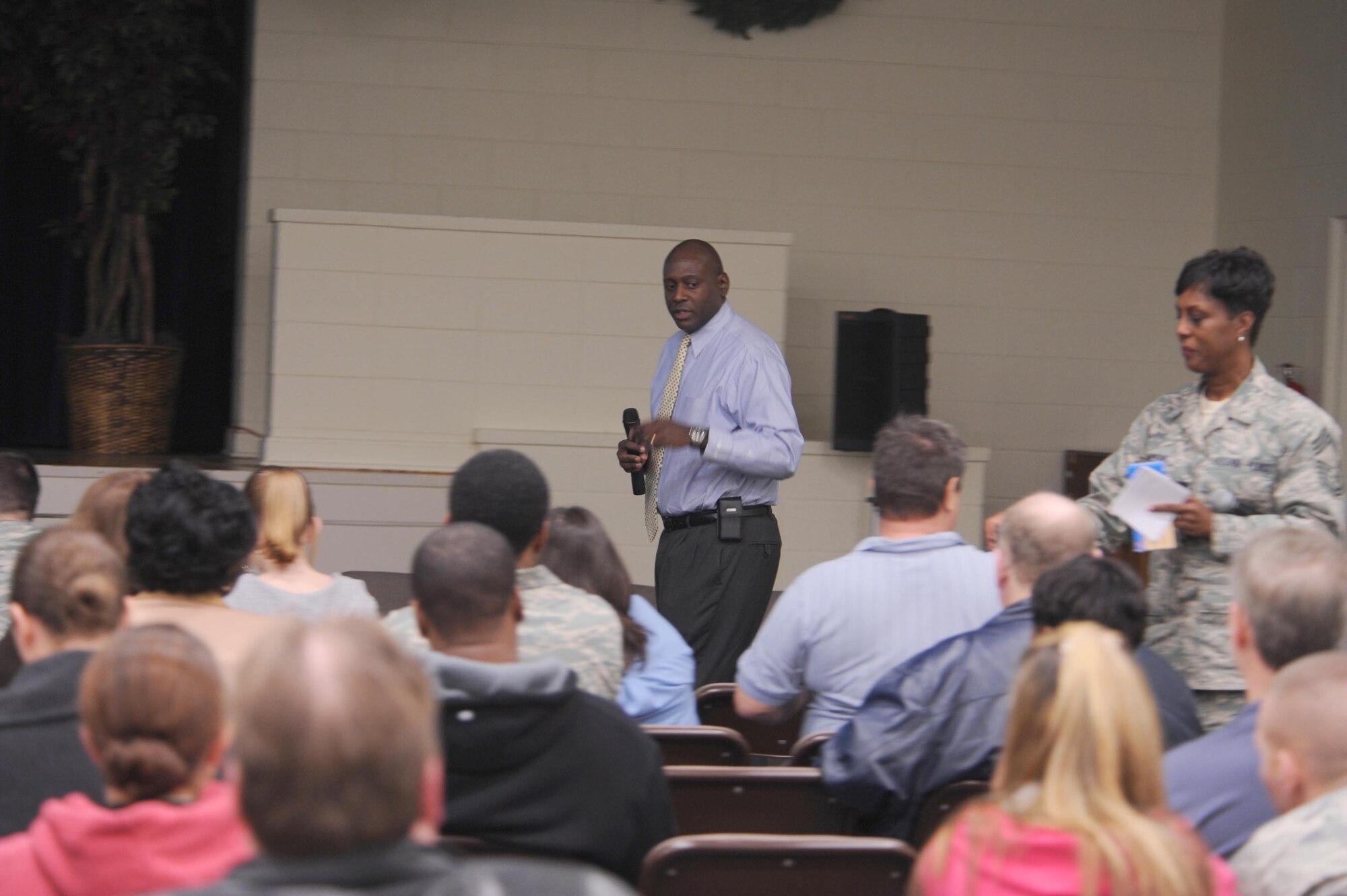 SHAW AIR FORCE BASE, S.C.-- Jonathan Bright, Shaw Base Exchange Manager, speaks to military families during a town hall meeting at the Community Center while Chief Master Sgt. Malissa Thompkins, 20th Logistics Readiness Squadron chief enlisted Manager, hands out questionare cards, Jan. 29. The town hall meeting is a gathering of Shaw members to learn and ask questions about upcoming events around the base.  (U.S. Air Force photo/Senior Airman William Coleman)