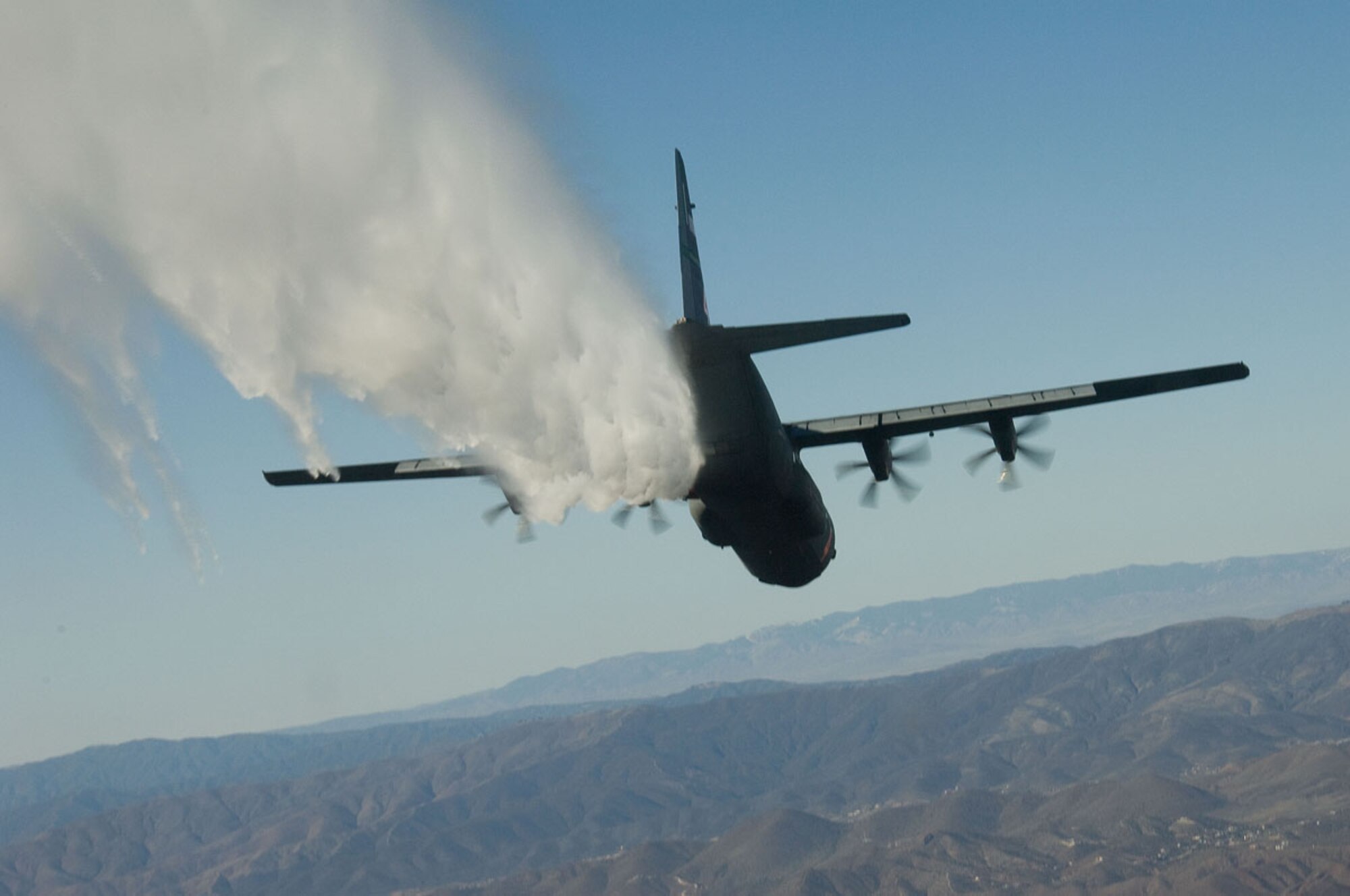A California Air National Guard C-130J Hercules cargo aircraft from the 146th Airlift Wing releases water in a test of a new Modular Airborne Fire Fighting System (MAFFS) system in late January. The 146th was the first unit to be approved for use of the new MAFFS II system. Photo by Master Sgt. Dave Buttner, California National Guard.