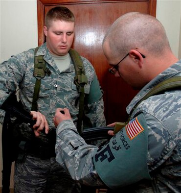 SOUTHWEST ASIA -- Staff Sgt. Michael Seeber, 380th Expeditionary Security Forces Squadron, performs the final step of a weapon clearing process for Airman 1st Class Jonathon Bennett, also of the 380th ESFS. Weapons are verified clear and safe before a magazine is inserted. Both are deployed from the 96th Security Forces Squadron at Eglin AFB, Fla. (U.S. Air Force photo/Staff Sgt. Mike Andriacco (released)